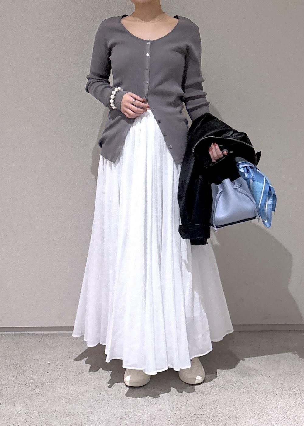 ブルー系のハンドバッグ、グレー系のカーディガン/ボレロ、ホワイト系のスカートを着用したレディースの冬コーディネートの4枚目の写真