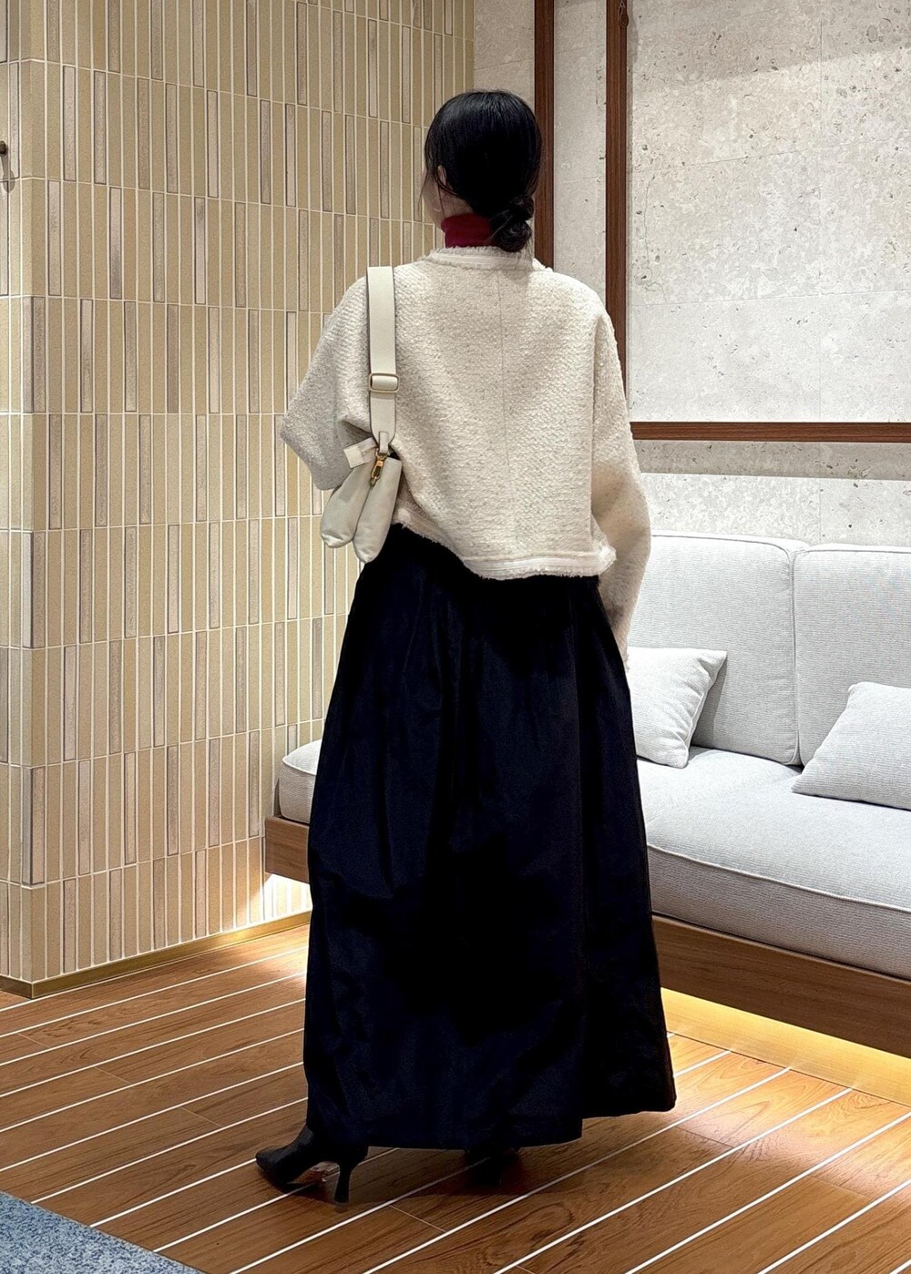 ブラック系のスカート、ブラック系のブーツ、レッド系のニット/セーターを着用したレディースの秋コーディネートの4枚目の写真