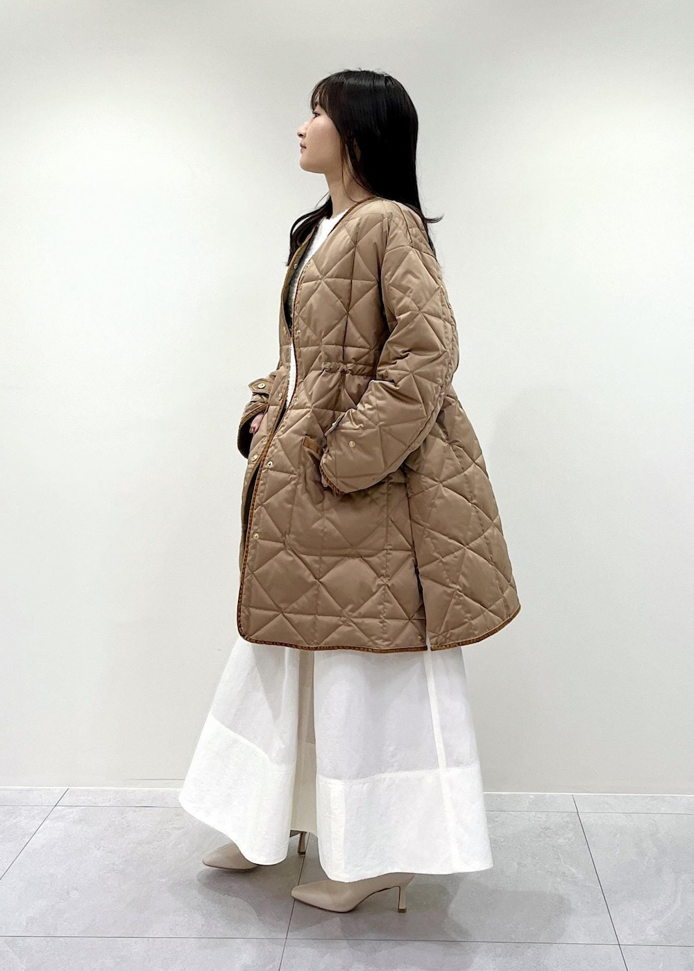 「Winter Coat 2023、ベージュ、ブラウン、ノーカラー、ダウン、キルティング、ミディアム、ホワイト、Knit 2023、ROPÉ、ニット、冬コート、スカート、ブーツ、骨格ウェーブ」｜「ROPE'の【雑誌掲載】【一部WEB限定】ナロースクエアトゥストレッチヒールショートブーツ（ブーツ、ホワイト系）」を使った、AYAさん（レディース・158cm）の秋コーディネートの2枚目の写真