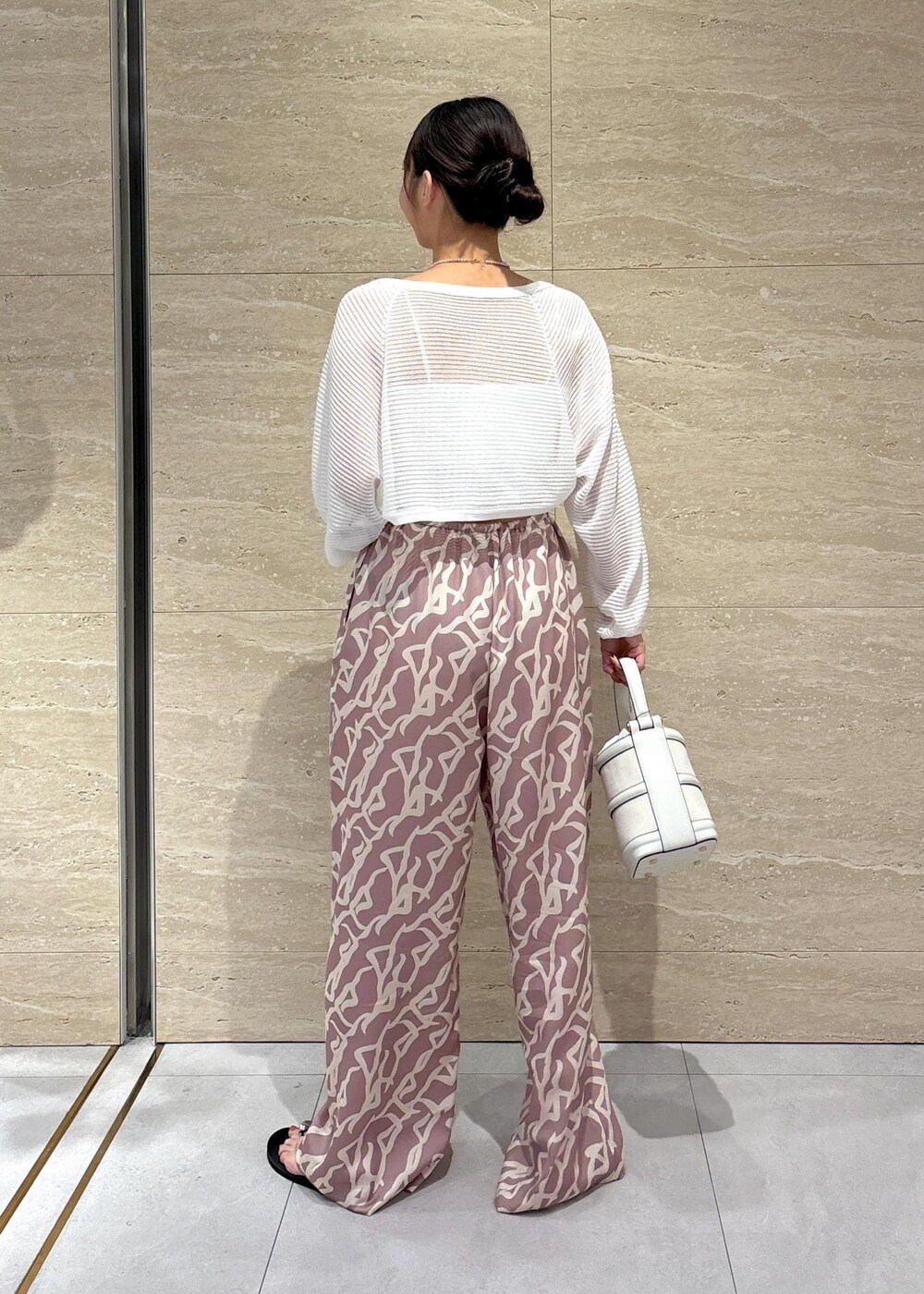 イエロー系のその他パンツ、ホワイト系のハンドバッグ、ホワイト系のチューブトップを着用したレディースの夏コーディネートの4枚目の写真