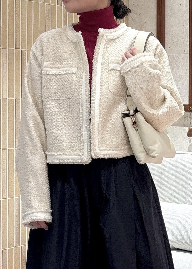 ブラック系のスカート、ブラック系のブーツ、レッド系のニット/セーターを着用したレディースの秋コーディネートの6枚目の写真