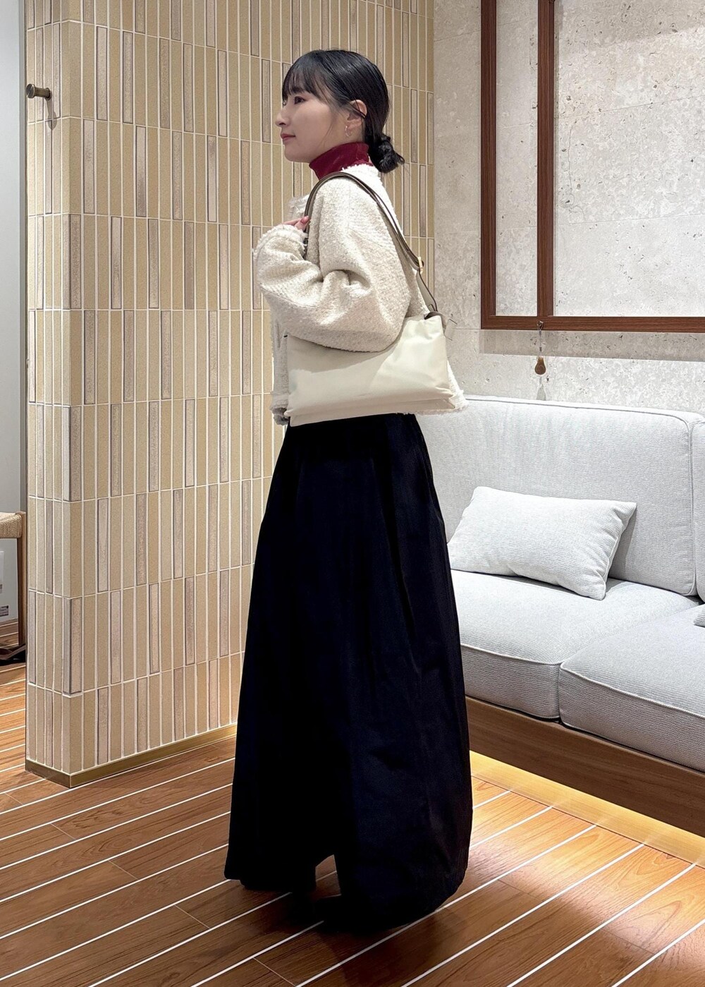 ブラック系のスカート、ブラック系のブーツ、レッド系のニット/セーターを着用したレディースの秋コーディネートの2枚目の写真