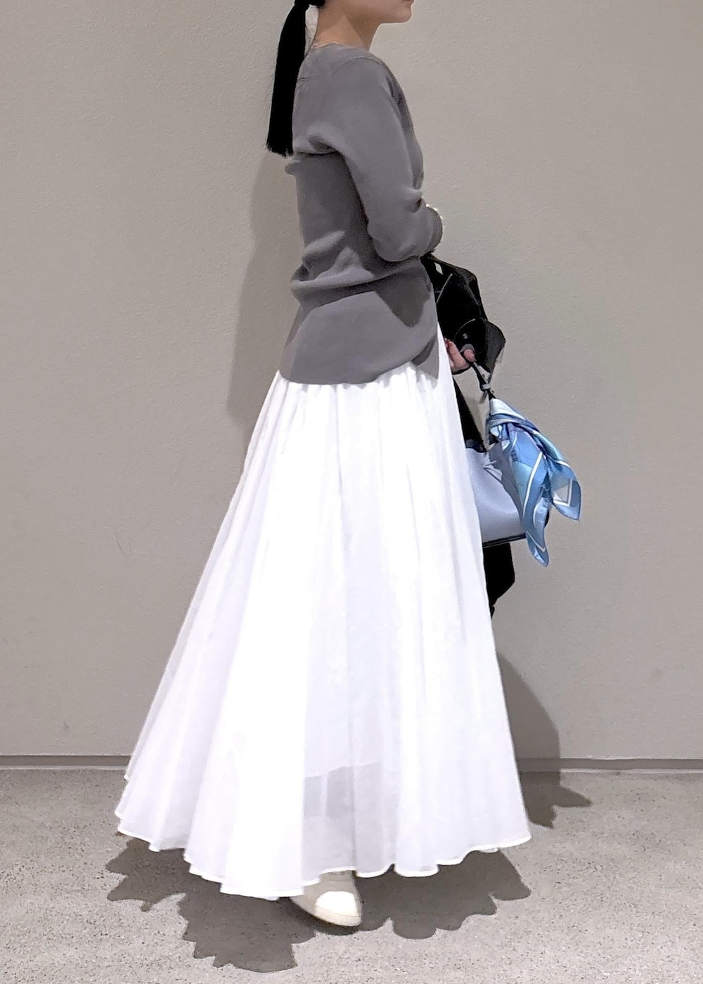 ブルー系のハンドバッグ、グレー系のカーディガン/ボレロ、ホワイト系のスカートを着用したレディースの冬コーディネートの5枚目の写真