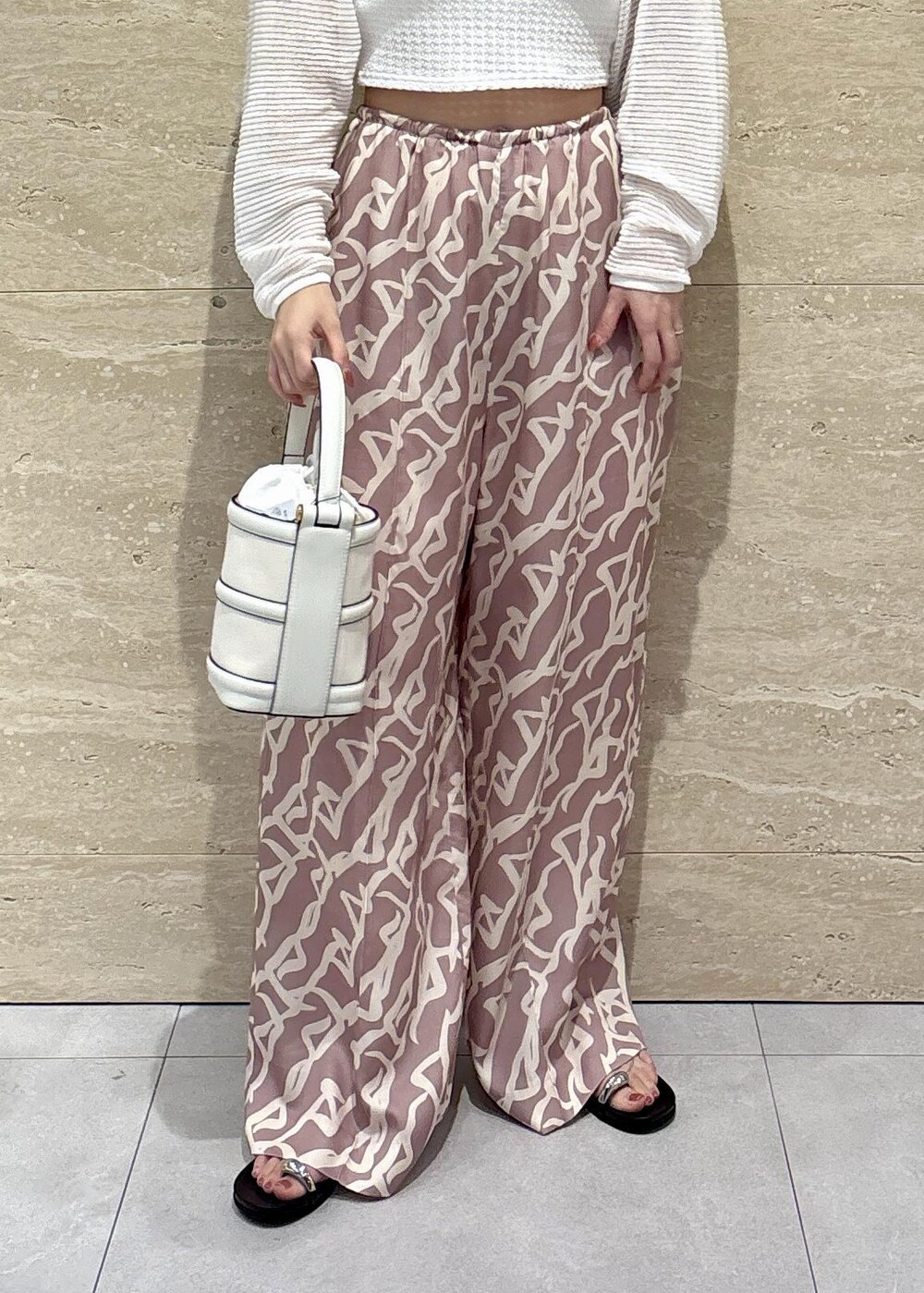 イエロー系のその他パンツ、ホワイト系のハンドバッグ、ホワイト系のチューブトップを着用したレディースの夏コーディネートの6枚目の写真