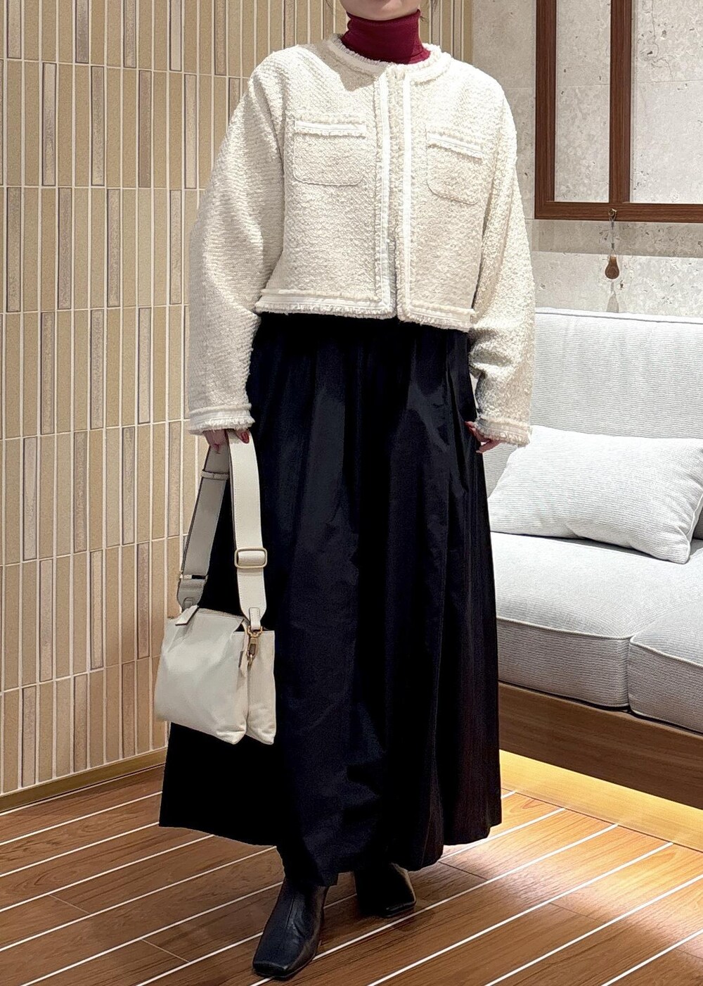 ブラック系のスカート、ブラック系のブーツ、レッド系のニット/セーターを着用したレディースの秋コーディネートの5枚目の写真