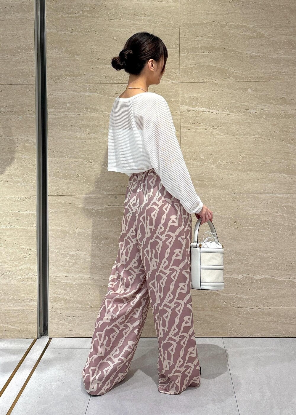 イエロー系のその他パンツ、ホワイト系のハンドバッグ、ホワイト系のチューブトップを着用したレディースの夏コーディネートの2枚目の写真