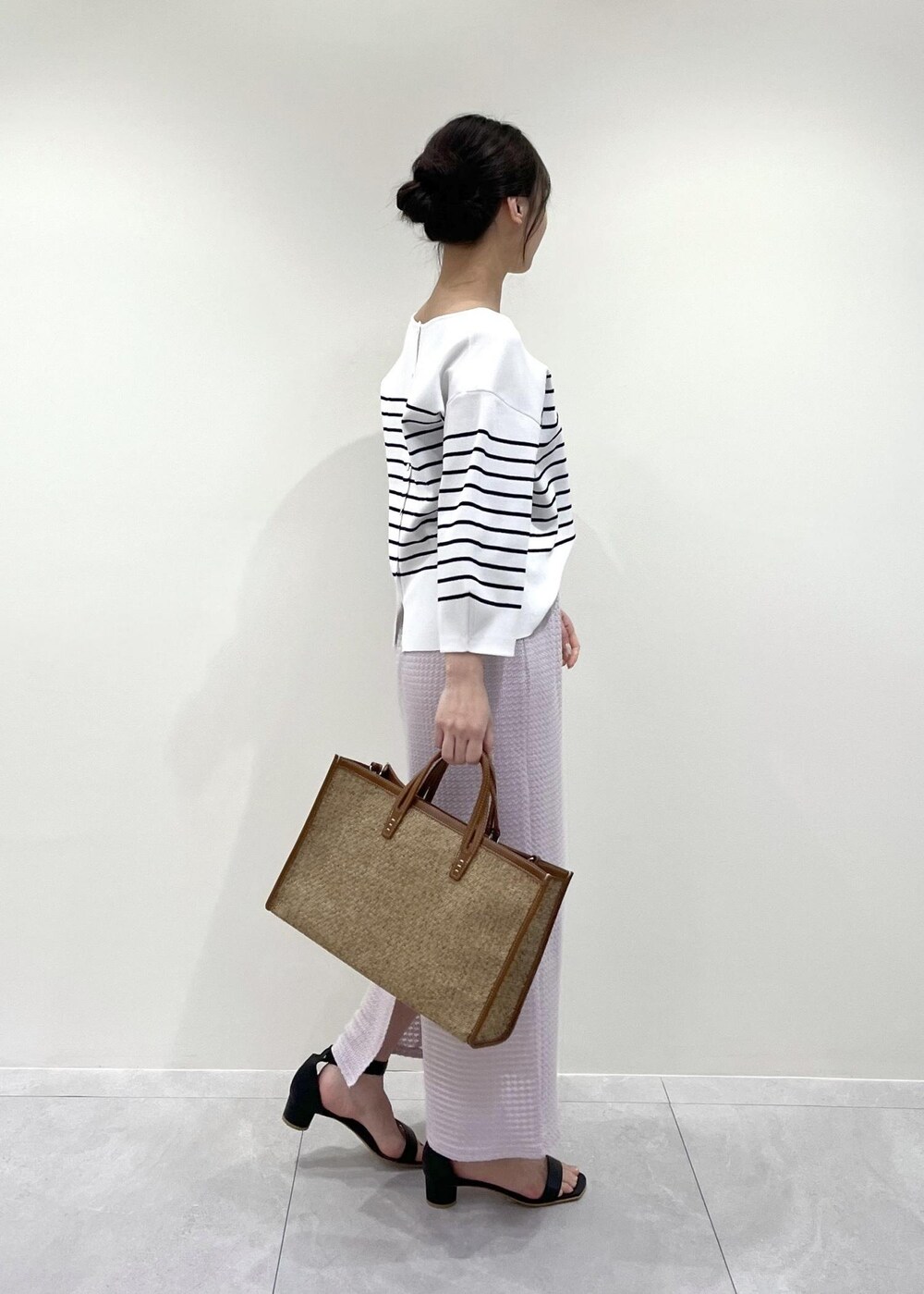 ピンク系のスカート、ホワイト系のニット/セーターを着用したレディースの春コーディネートの2枚目の写真