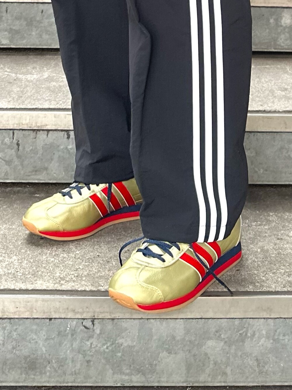 ゴールド系のシューズ、ブラック系のカーゴパンツ、レッド系のジャージを着用したメンズの冬コーディネートの3枚目の写真