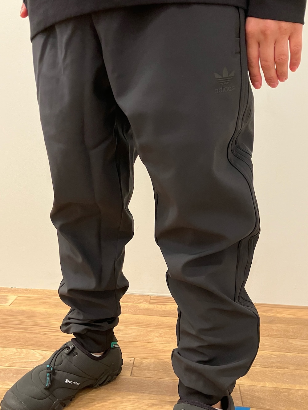 ブラック系のスウェットパンツ、ブラック系のパーカー、ブラック系のシューズを着用したメンズの秋コーディネートの3枚目の写真