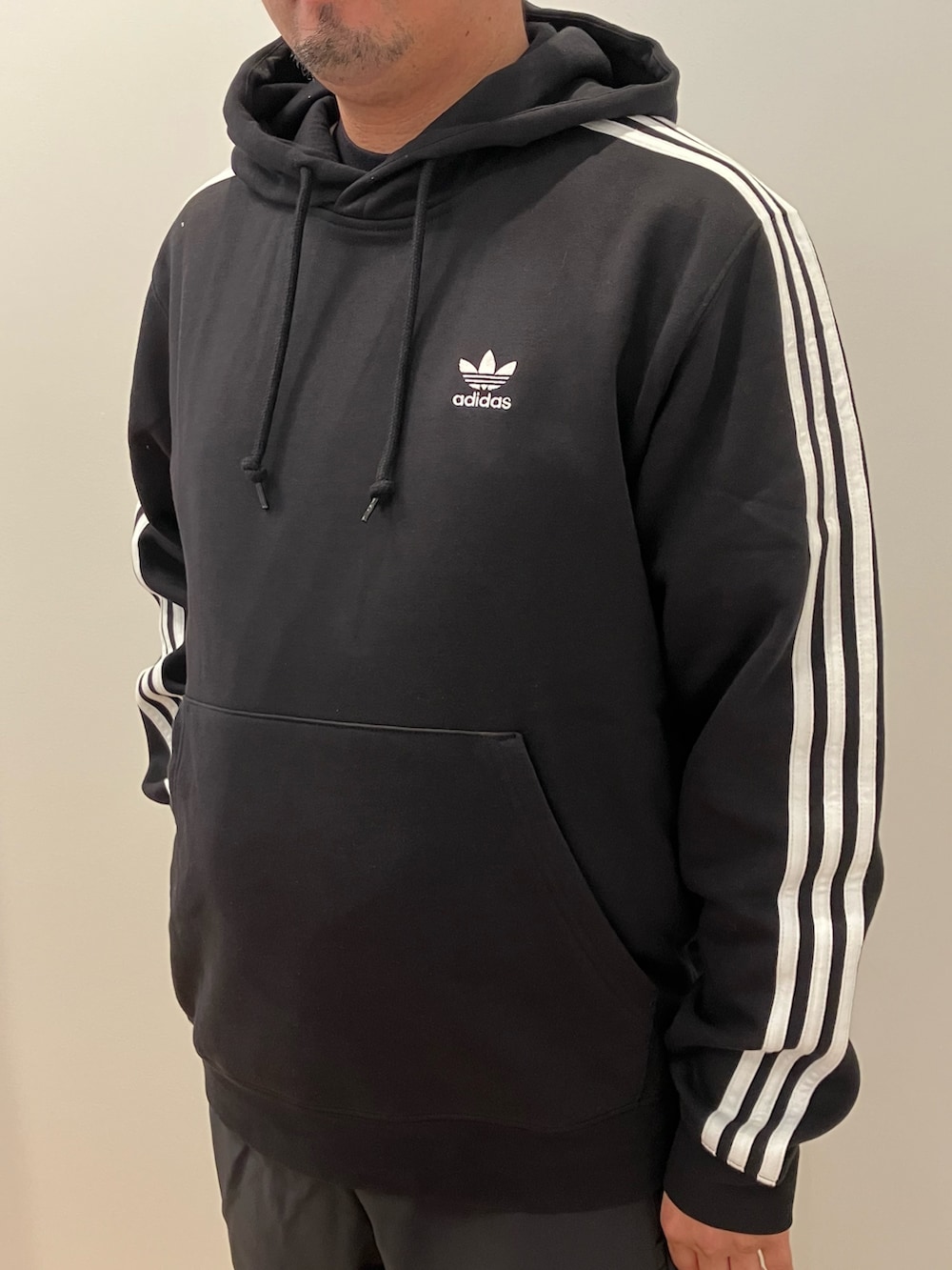 ブラック系のスウェットパンツ、ブラック系のパーカー、ブラック系のシューズを着用したメンズの秋コーディネートの2枚目の写真