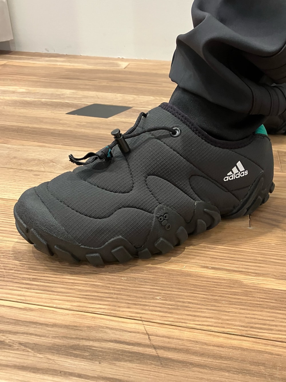 ブラック系のスウェットパンツ、ブラック系のパーカー、ブラック系のシューズを着用したメンズの秋コーディネートの4枚目の写真