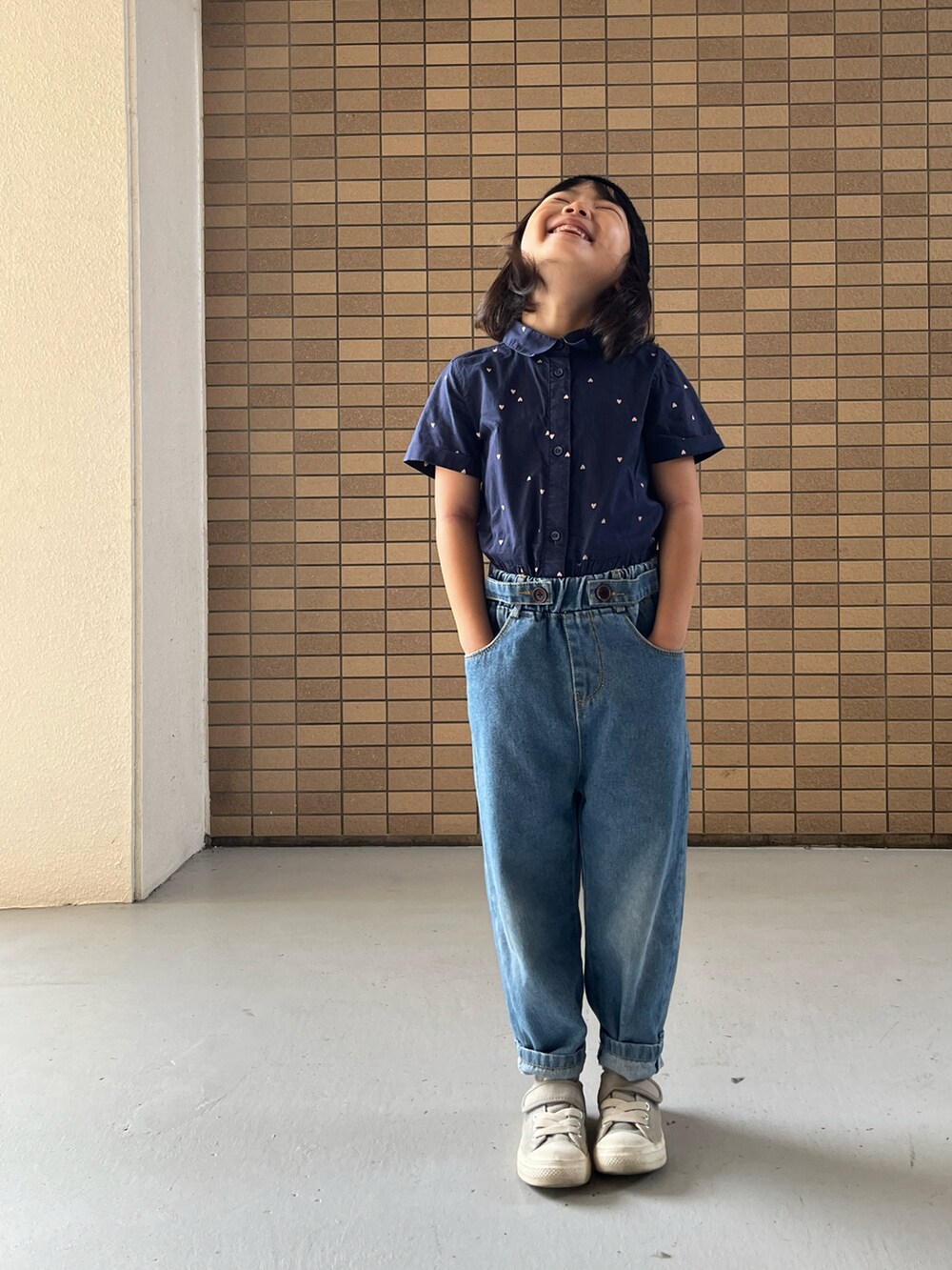 グレー系のスニーカー、ブルー系のシャツワンピース、ブラック系のハンチング/ベレー帽を着用したキッズの冬コーディネートの5枚目の写真