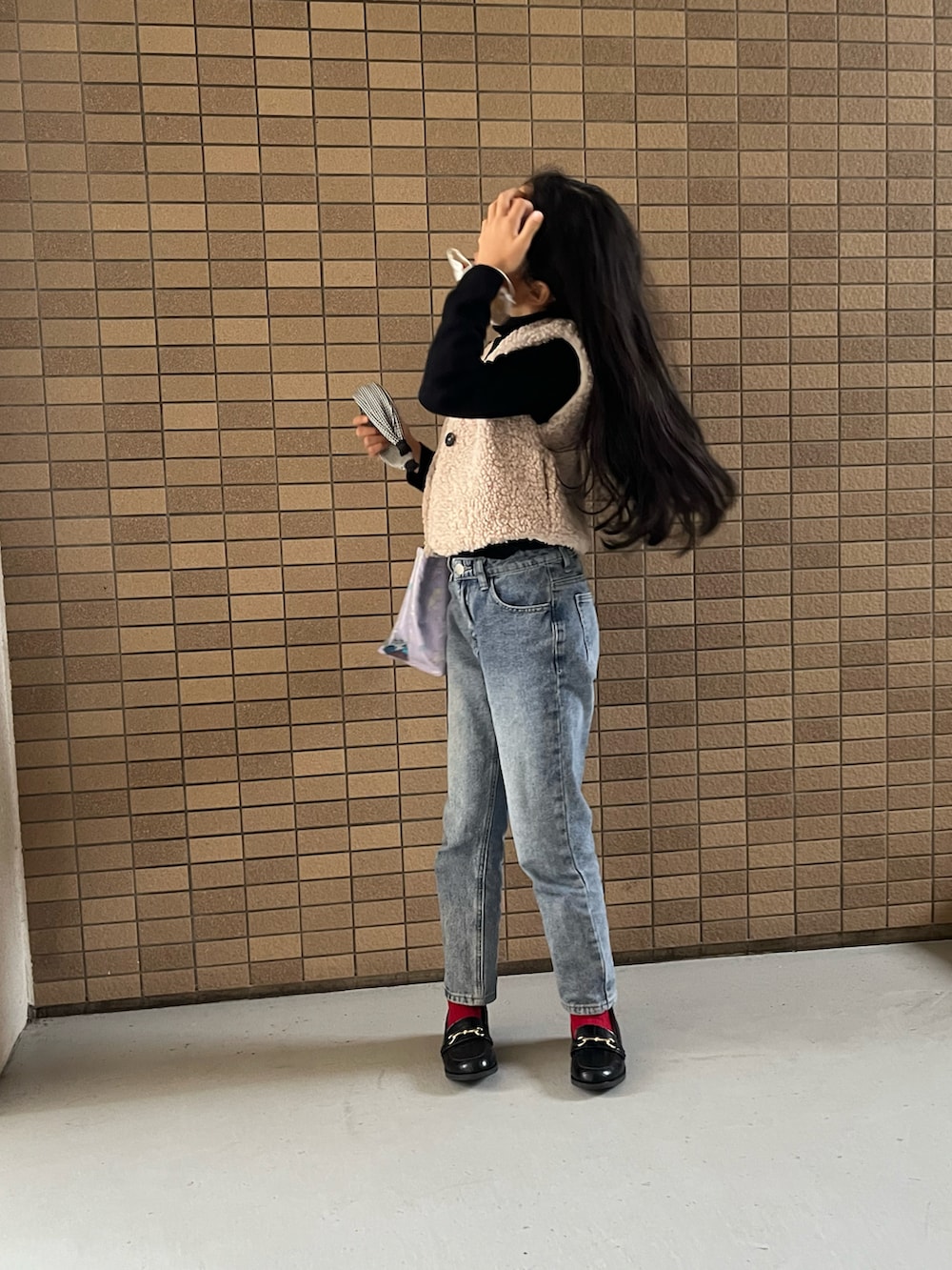 ブルー系のデニムパンツ、パープル系のトートバッグ、ブラック系のローファーを着用したキッズの冬コーディネートの3枚目の写真