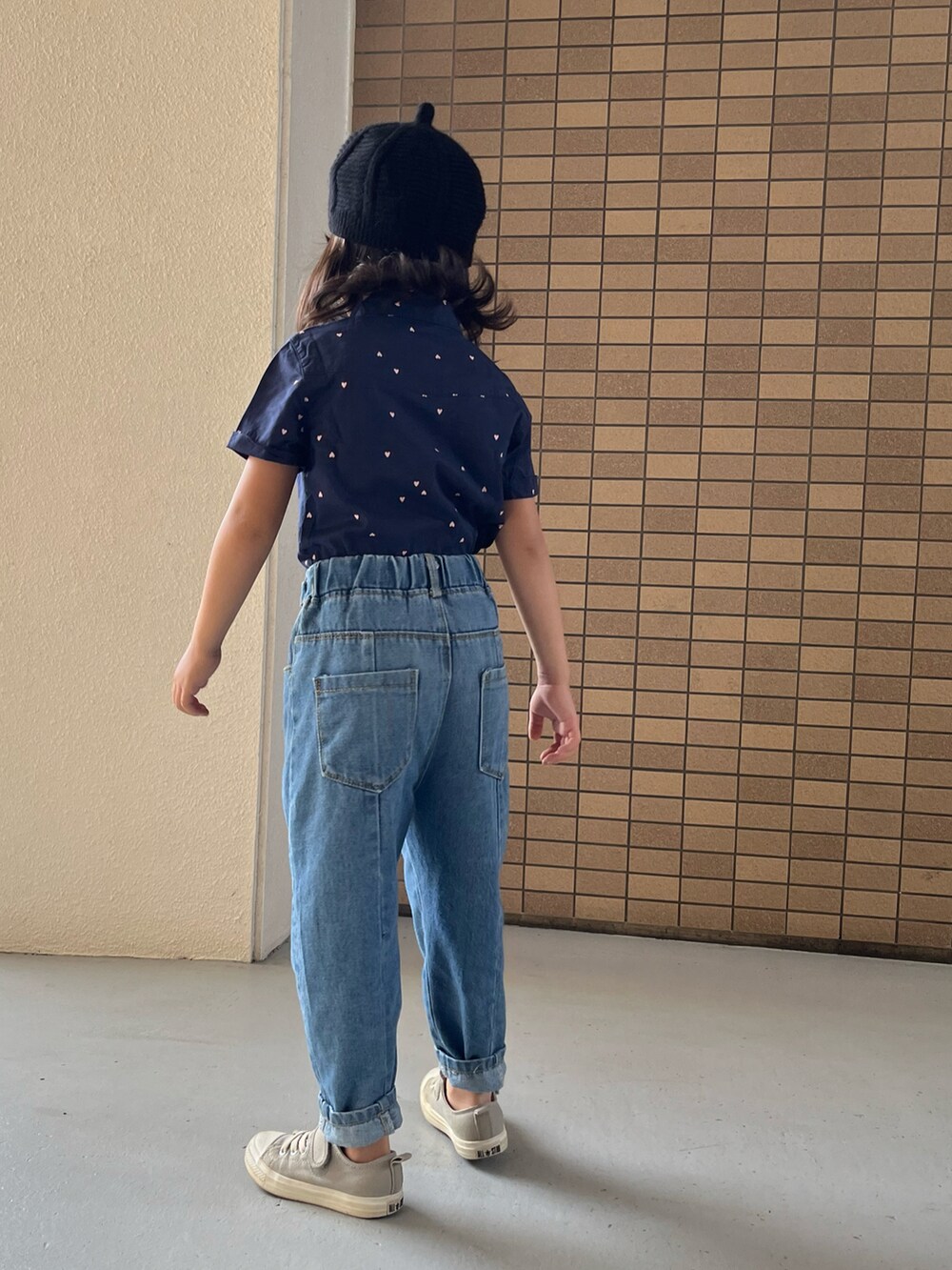 グレー系のスニーカー、ブルー系のシャツワンピース、ブラック系のハンチング/ベレー帽を着用したキッズの冬コーディネートの4枚目の写真