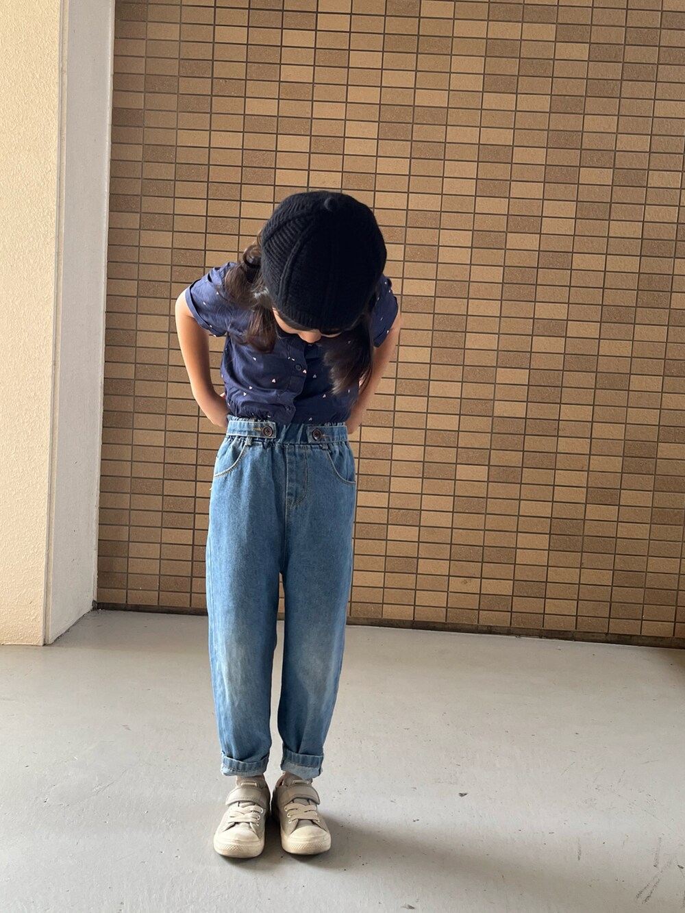 グレー系のスニーカー、ブルー系のシャツワンピース、ブラック系のハンチング/ベレー帽を着用したキッズの冬コーディネートの2枚目の写真