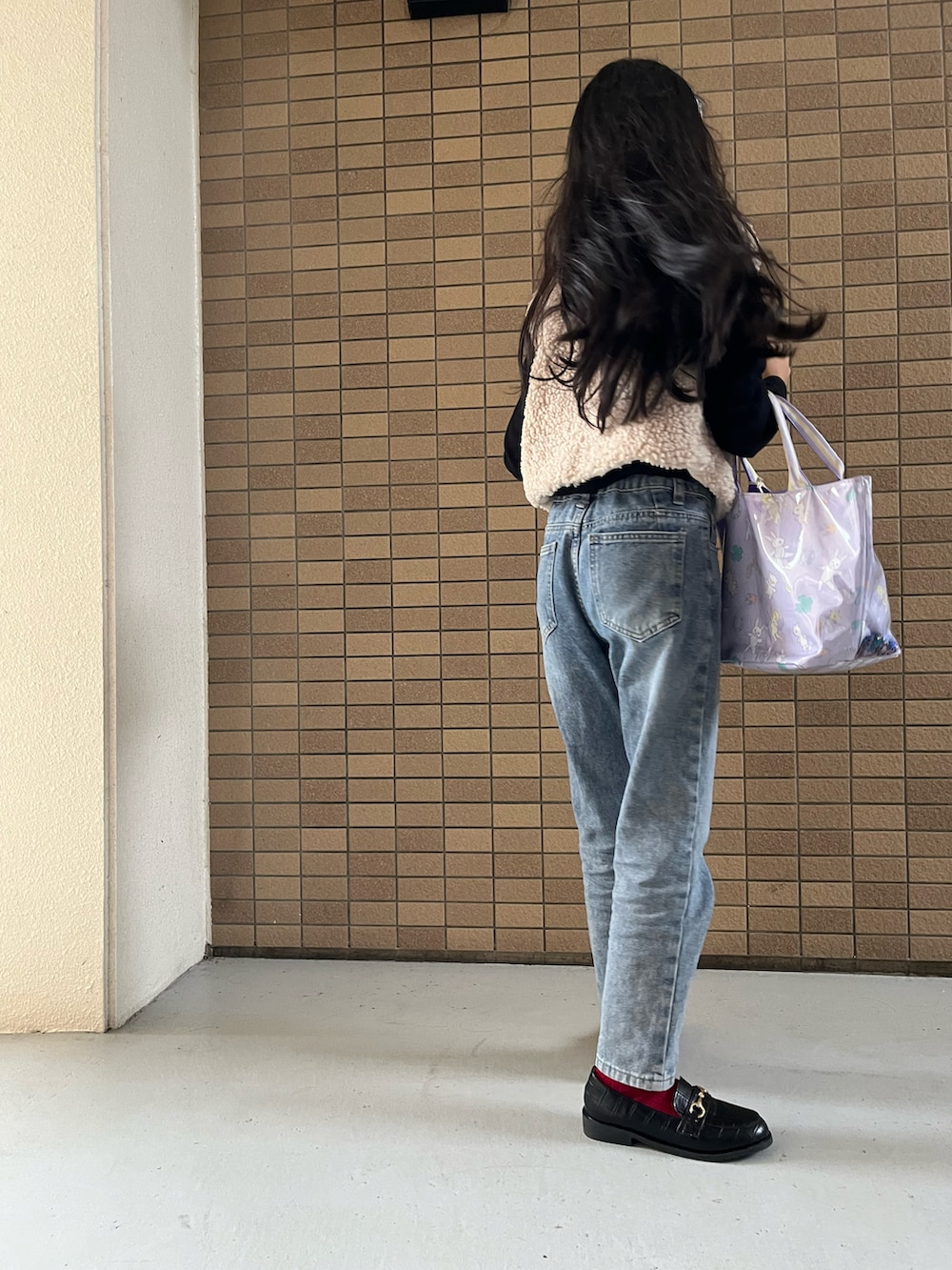 ブルー系のデニムパンツ、パープル系のトートバッグ、ブラック系のローファーを着用したキッズの冬コーディネートの2枚目の写真