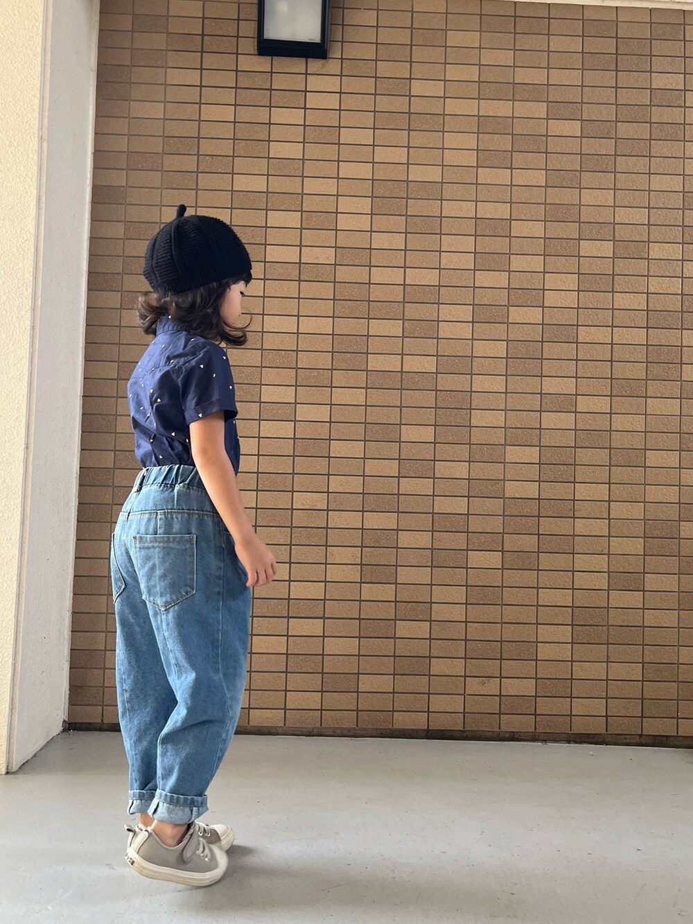 グレー系のスニーカー、ブルー系のシャツワンピース、ブラック系のハンチング/ベレー帽を着用したキッズの冬コーディネートの3枚目の写真