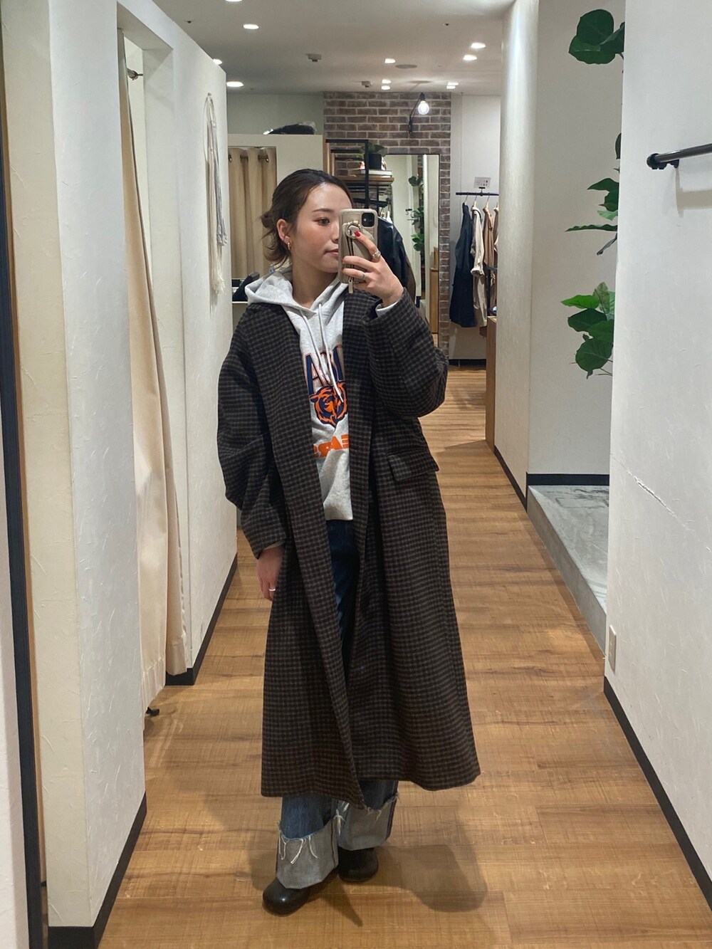 その他のチェスターコート、ブルー系のデニムパンツ、ブラック系のブーツを着用したレディースの秋コーディネートの2枚目の写真