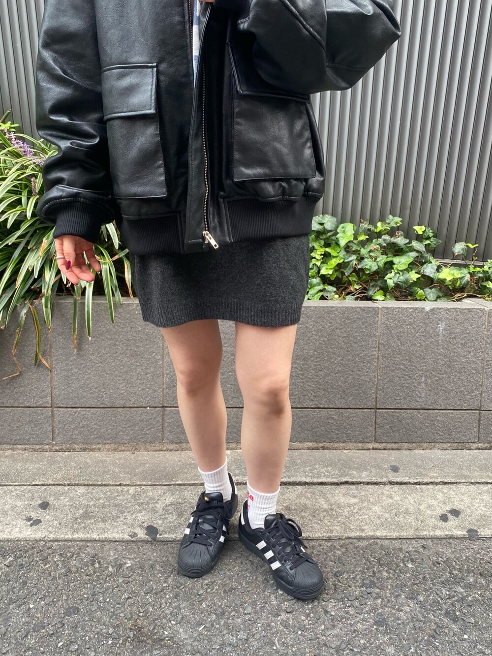 グレー系のスカート、ブラック系のブルゾン、グレー系のパーカーを着用したレディースの秋コーディネートの7枚目の写真