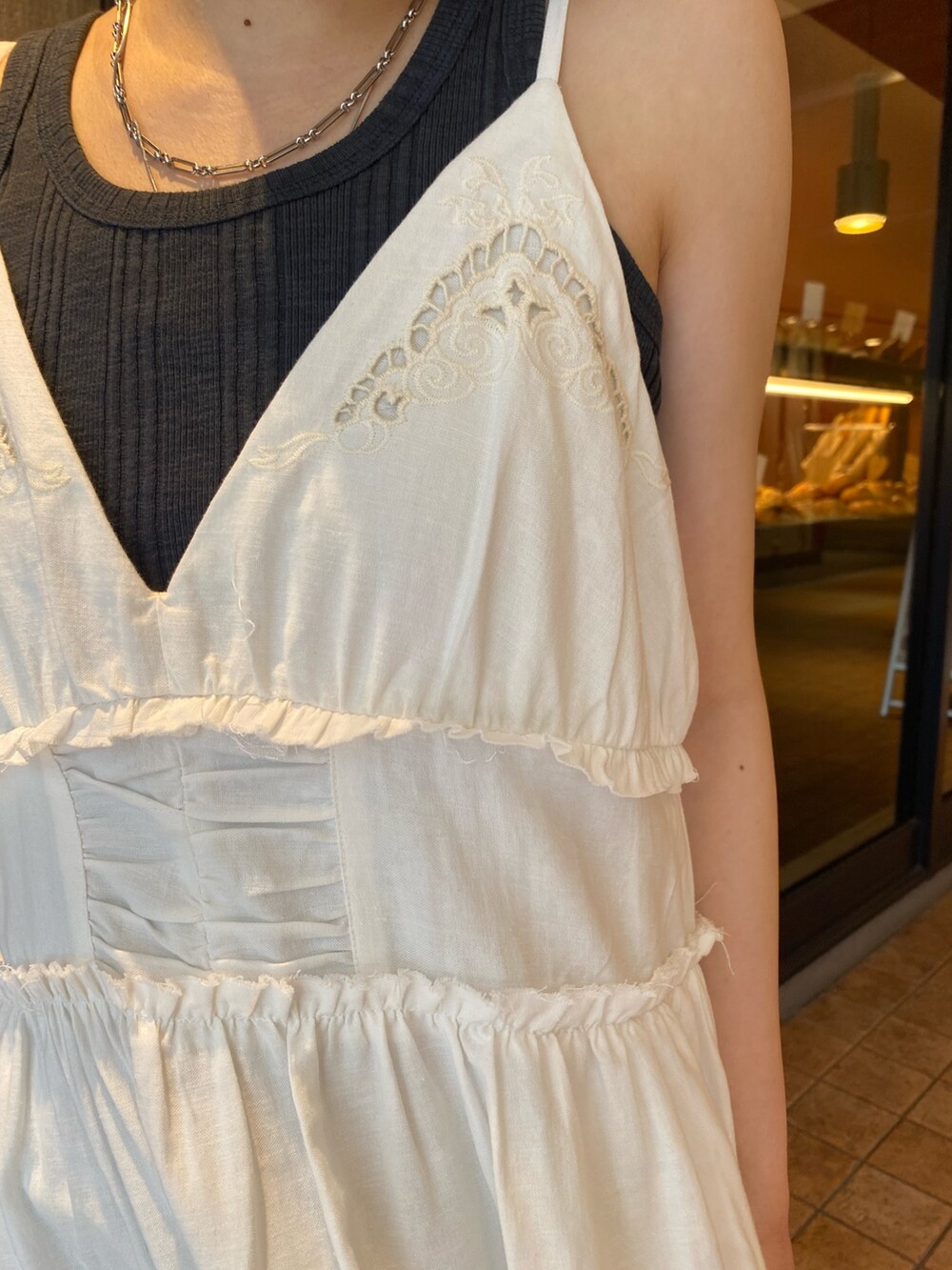 ホワイト系のワンピース、シルバー系のサンダル、グレー系のタンクトップを着用したレディースの春コーディネートの4枚目の写真