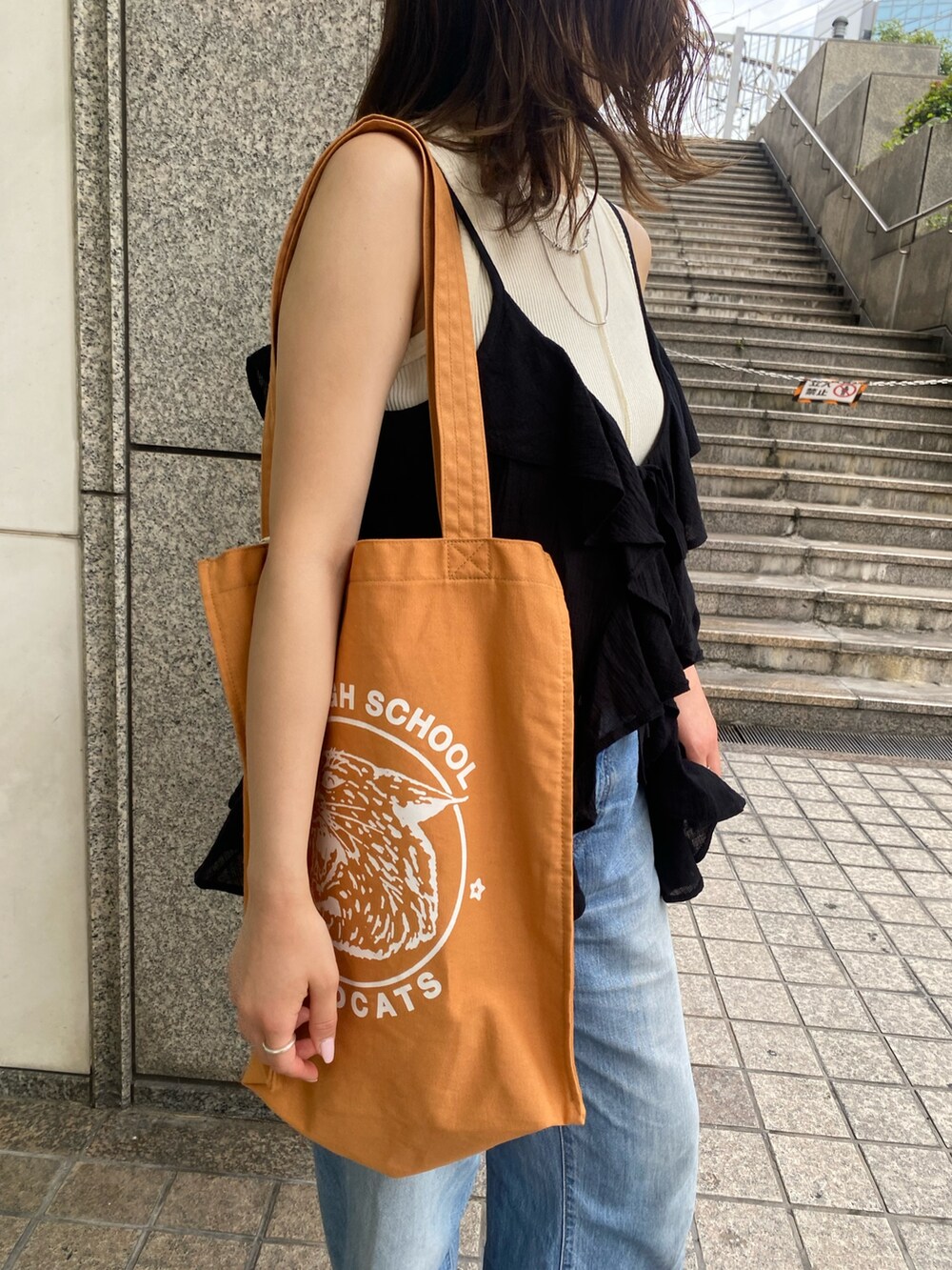 ブルー系のデニムパンツ、ブラック系のキャミソール、ホワイト系のタンクトップを着用したレディースの夏コーディネートの5枚目の写真