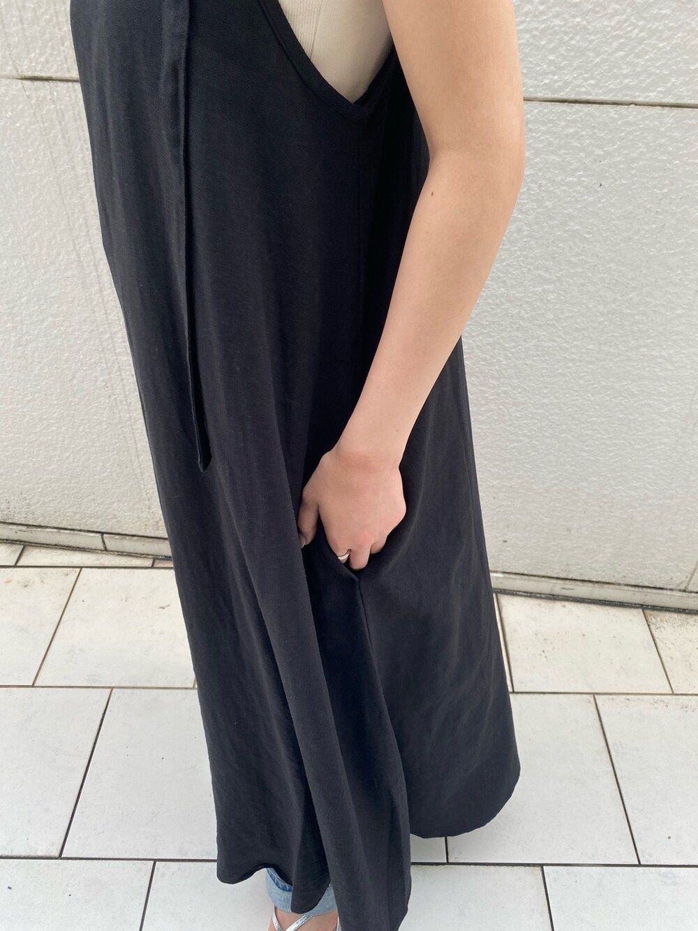 ブラック系のワンピース、ホワイト系のキャミソール、ブルー系のデニムパンツを着用したレディースの夏コーディネートの6枚目の写真