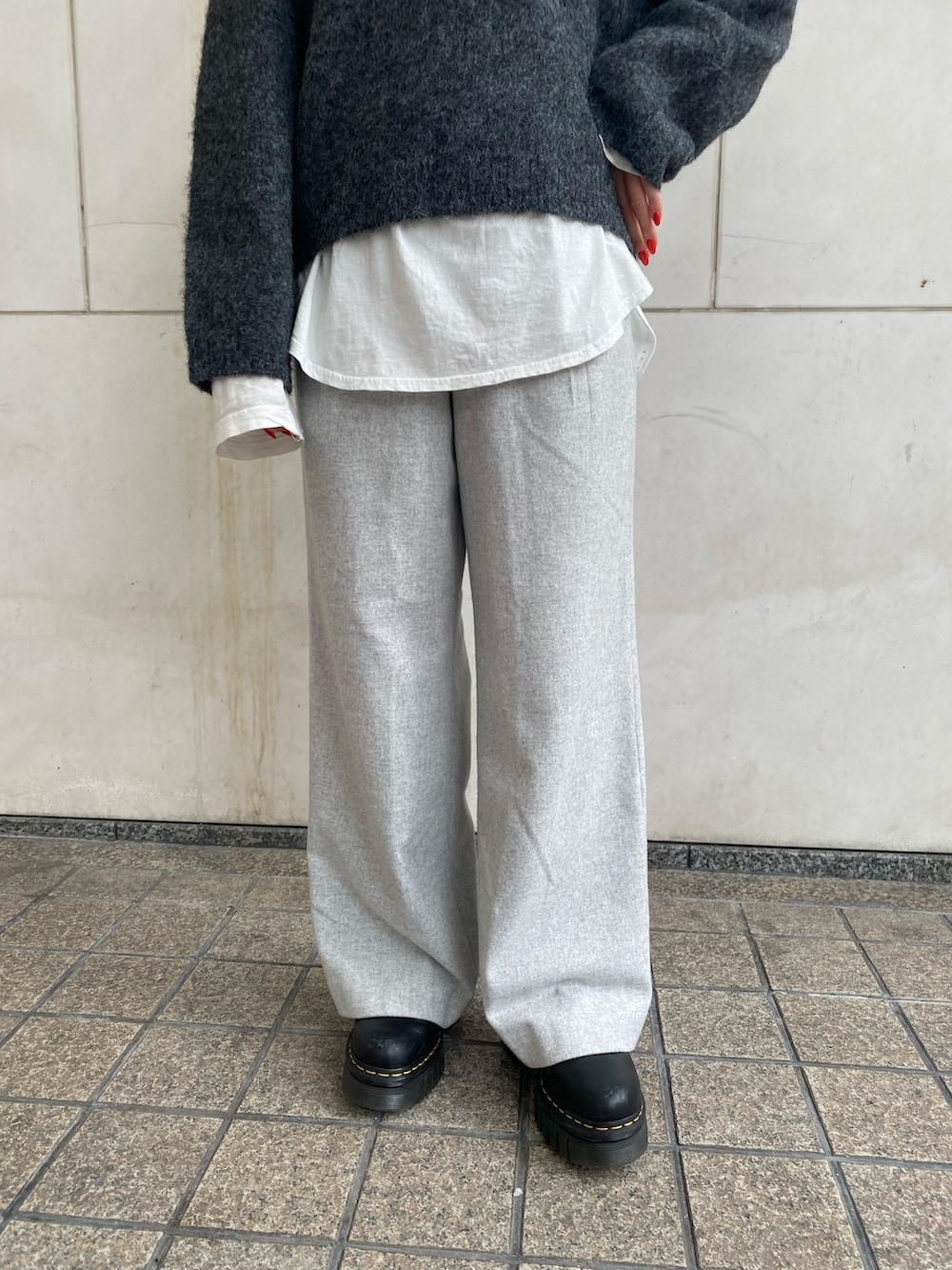 グレー系のニット/セーター、ホワイト系のTシャツ/カットソー、グレー系のその他パンツを着用したレディースの冬コーディネートの5枚目の写真