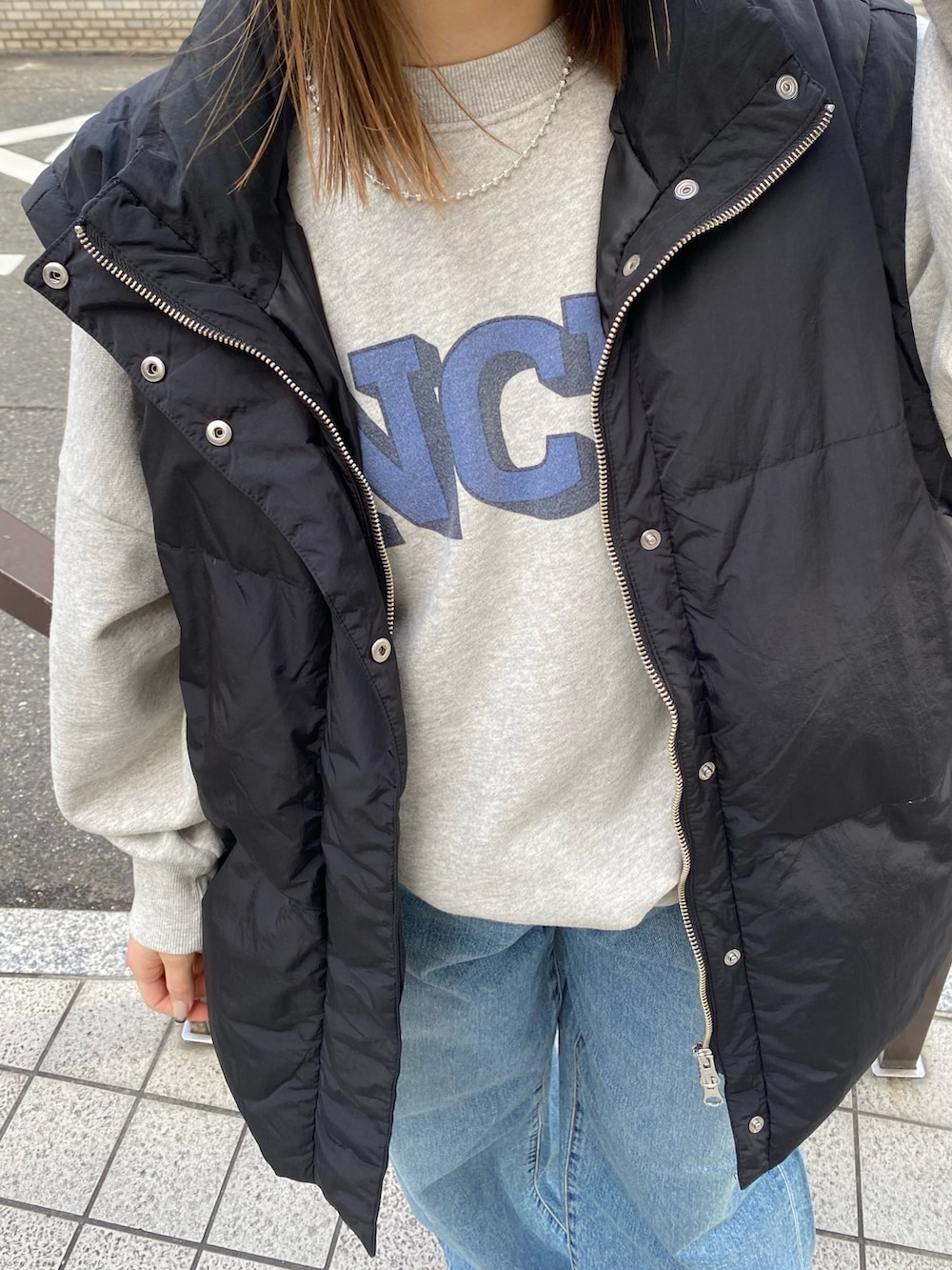 ブルー系のデニムパンツ、グレー系のスウェット、ブラック系のダウンジャケット/コートを着用したレディースの冬コーディネートの6枚目の写真