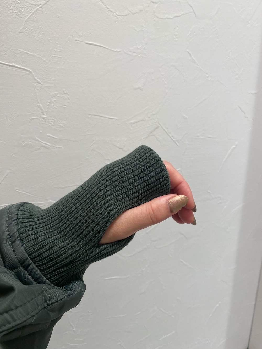 ベージュ系のブルゾン、グレー系のパーカー、ブルー系のデニムパンツを着用したレディースの秋コーディネートの4枚目の写真