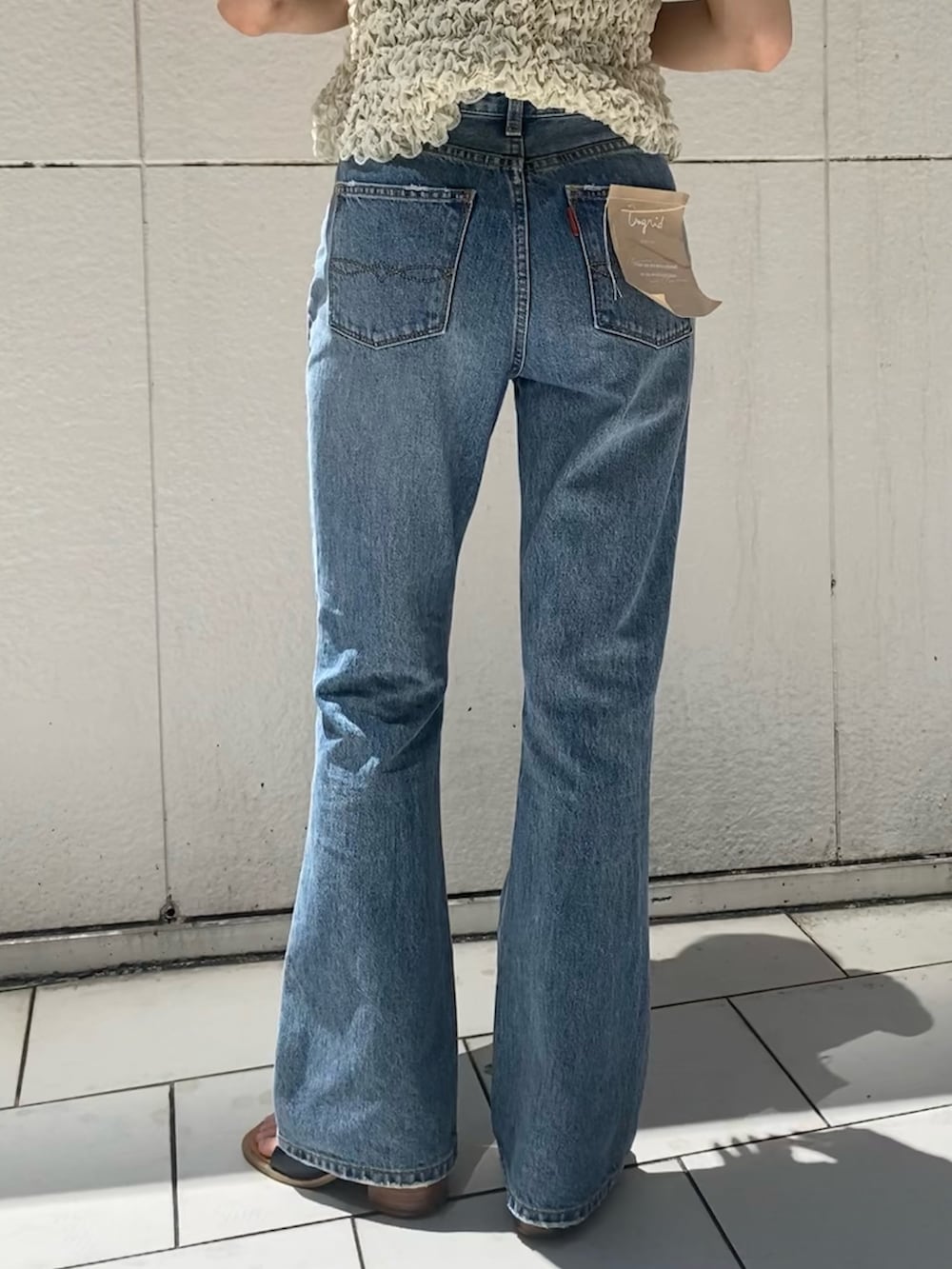 ブルー系のデニムパンツ、ホワイト系のシャツ/ブラウス、ブラック系のサンダルを着用したレディースの夏コーディネートの6枚目の写真