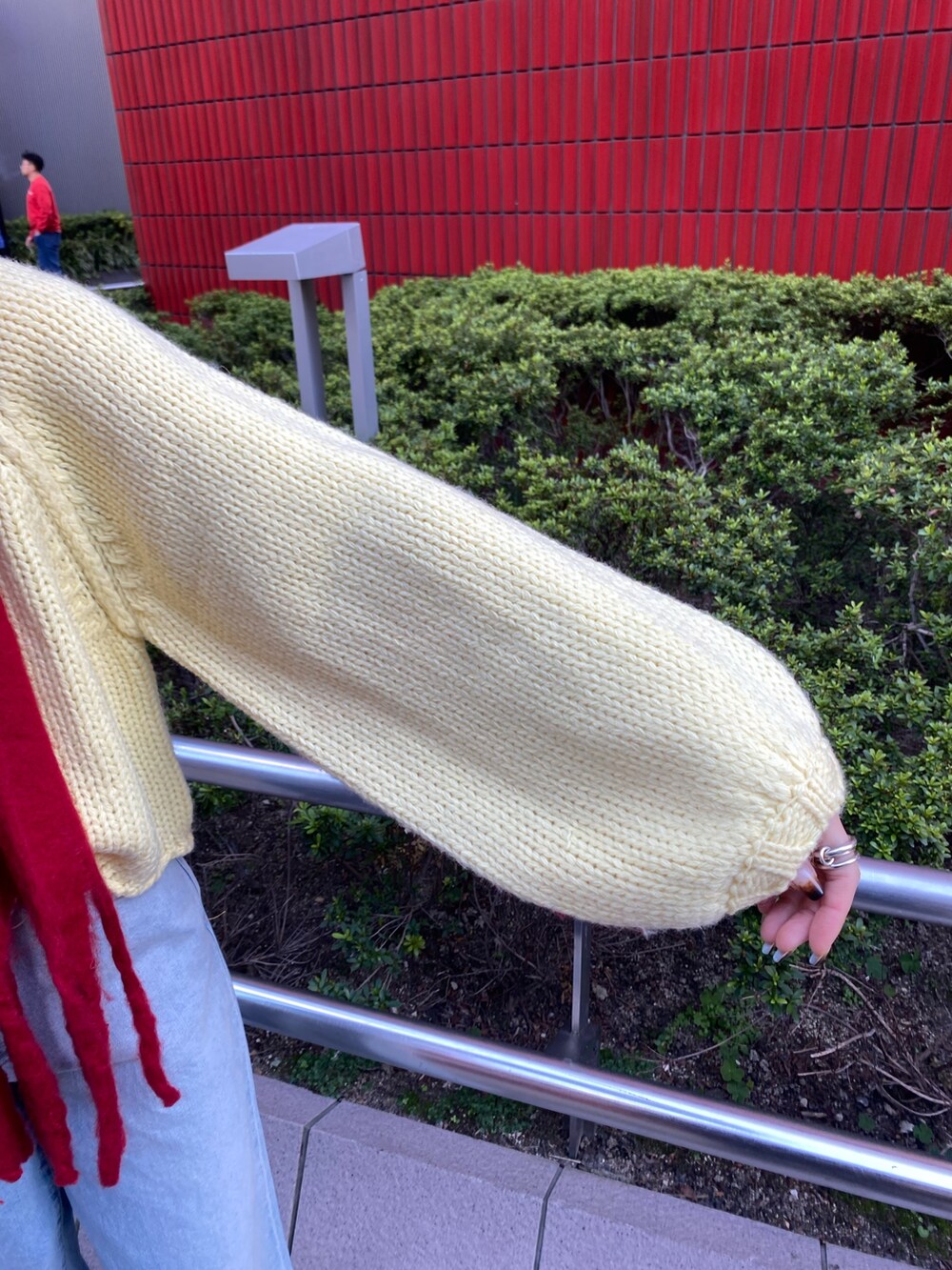 ブルー系のデニムパンツ、イエロー系のニット/セーター、ブラウン系のブーツを着用したレディースの秋コーディネートの7枚目の写真