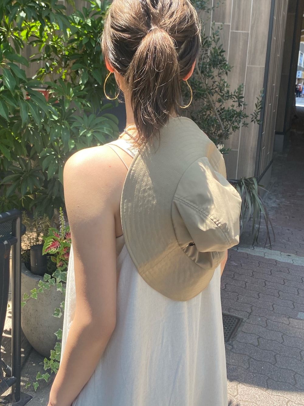 ホワイト系のワンピース、ブルー系のデニムパンツ、ベージュ系のハットを着用したレディースの夏コーディネートの4枚目の写真