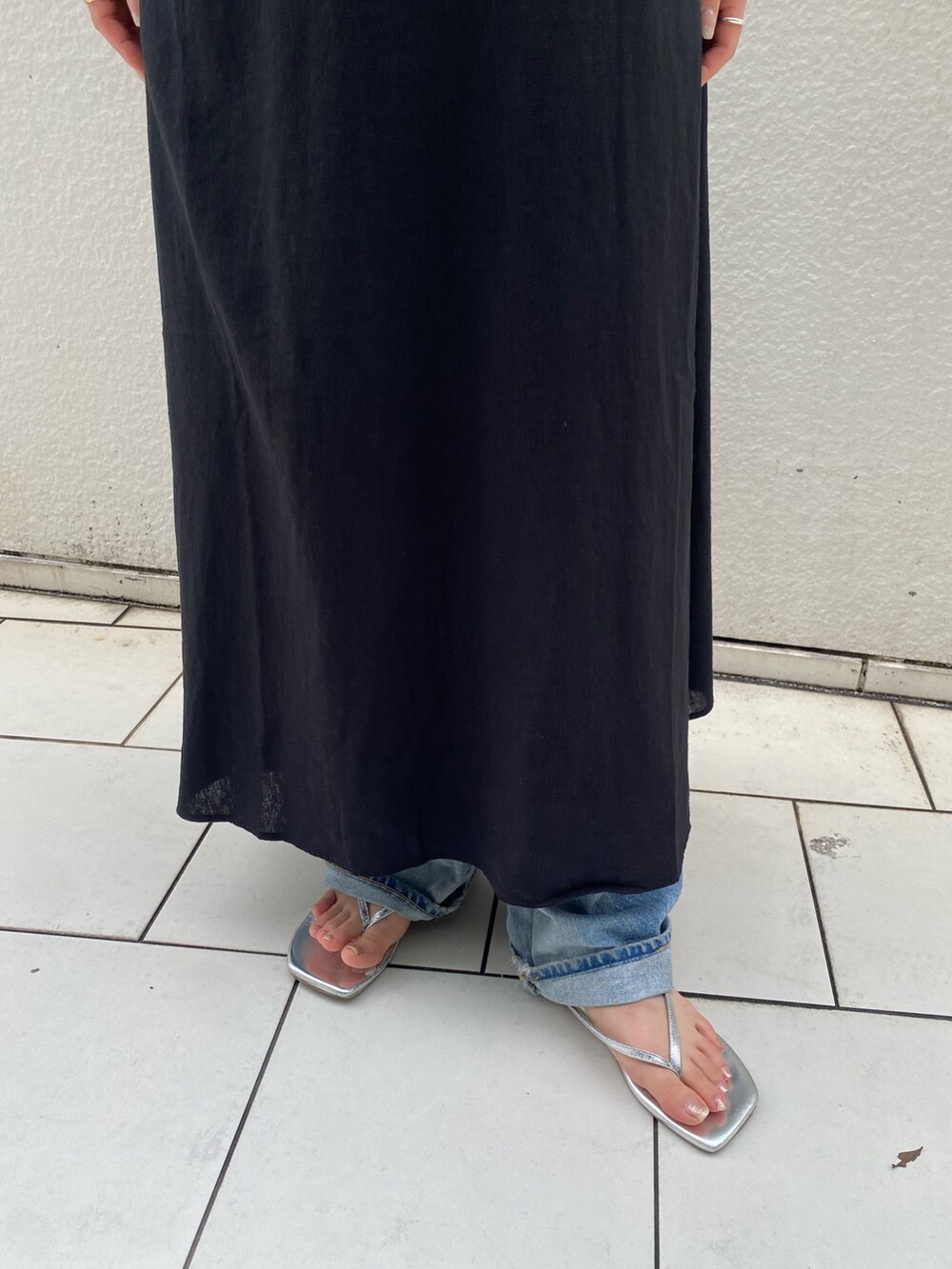 ブラック系のワンピース、ホワイト系のキャミソール、ブルー系のデニムパンツを着用したレディースの夏コーディネートの5枚目の写真