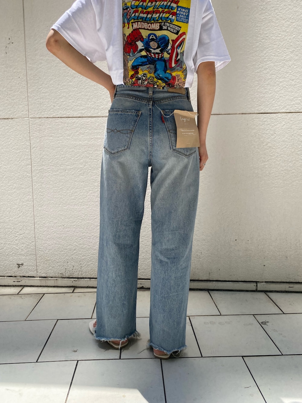 ブルー系のデニムパンツ、ホワイト系のサンダル、ホワイト系のTシャツ/カットソーを着用したレディースの夏コーディネートの5枚目の写真