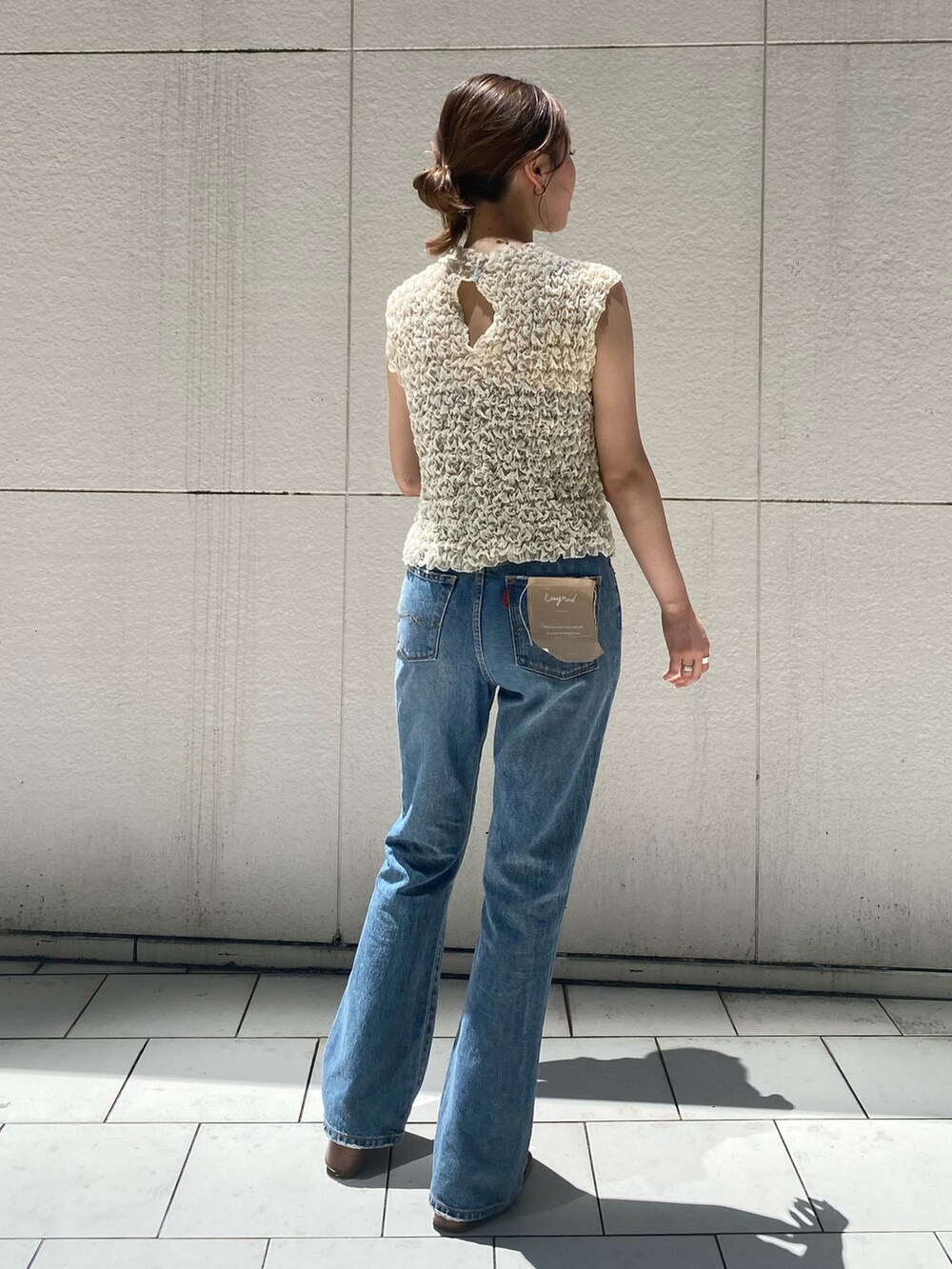 ブルー系のデニムパンツ、ホワイト系のシャツ/ブラウス、ブラック系のサンダルを着用したレディースの夏コーディネートの3枚目の写真