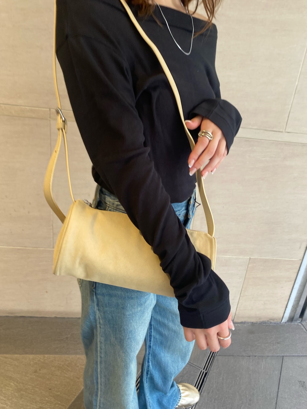 ブルー系のデニムパンツ、ブラック系のTシャツ/カットソー、ゴールド系のバレエシューズを着用したレディースの夏コーディネートの4枚目の写真