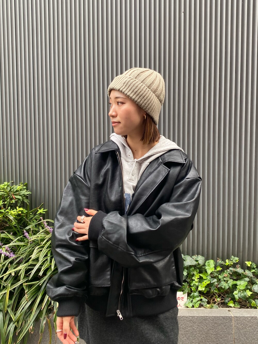 グレー系のスカート、ブラック系のブルゾン、グレー系のパーカーを着用したレディースの秋コーディネートの5枚目の写真