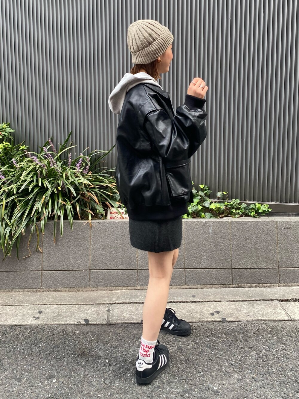 グレー系のスカート、ブラック系のブルゾン、グレー系のパーカーを着用したレディースの秋コーディネートの2枚目の写真