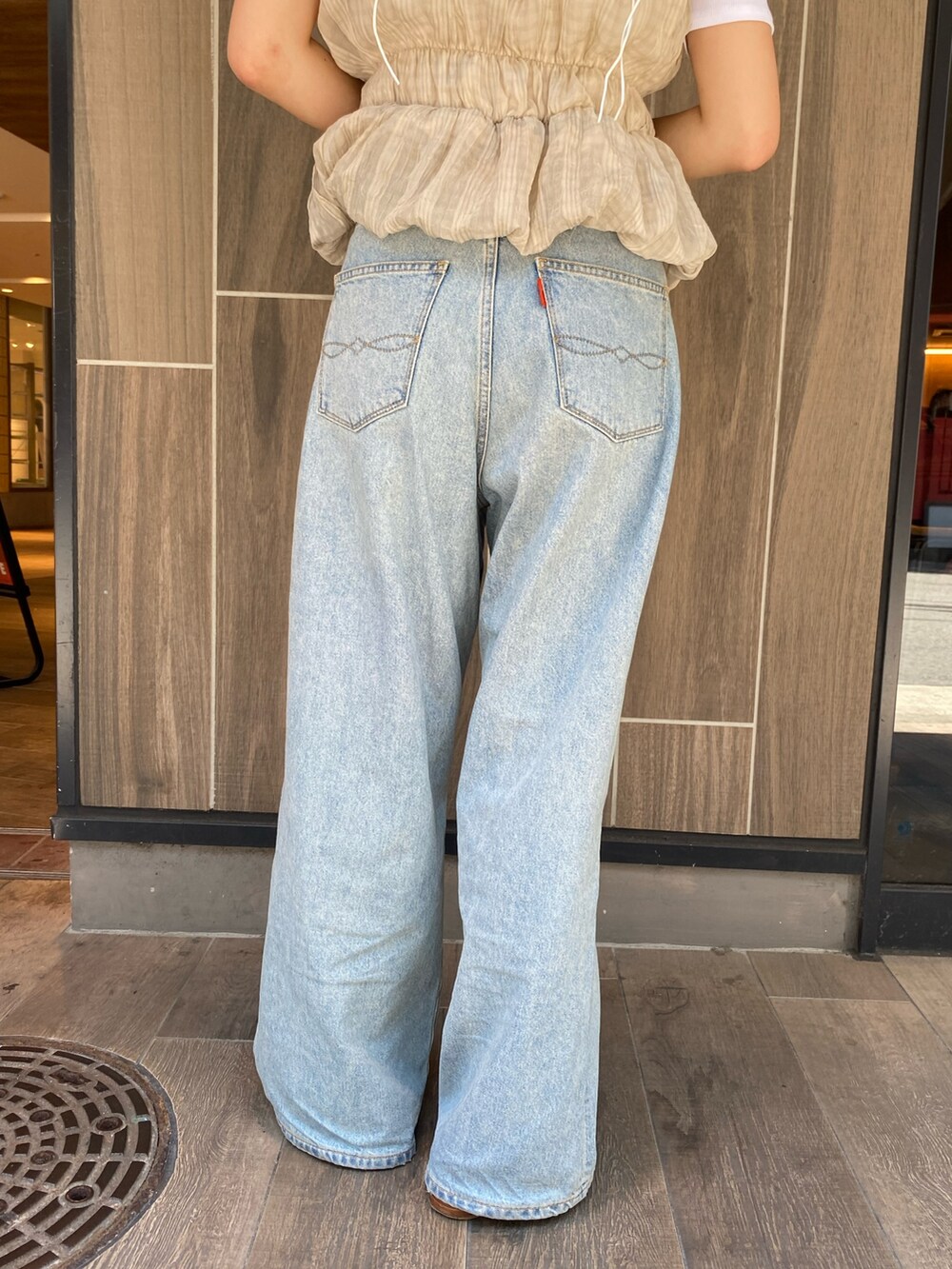 ブラック系のTシャツ/カットソー、ブルー系のデニムパンツ、ブラック系のサンダルを着用したレディースの夏コーディネートの6枚目の写真