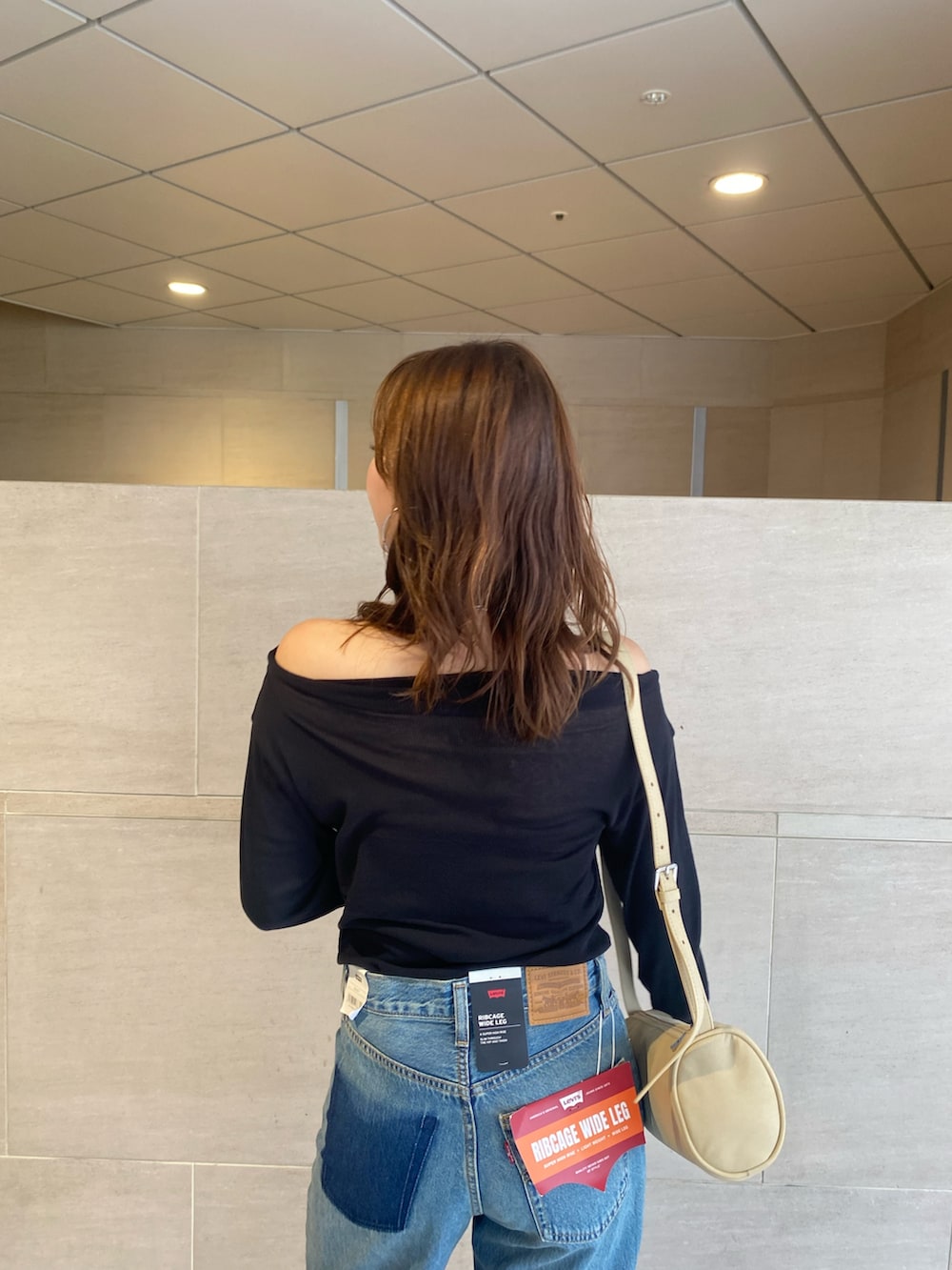 ブルー系のデニムパンツ、ブラック系のTシャツ/カットソー、ゴールド系のバレエシューズを着用したレディースの夏コーディネートの5枚目の写真