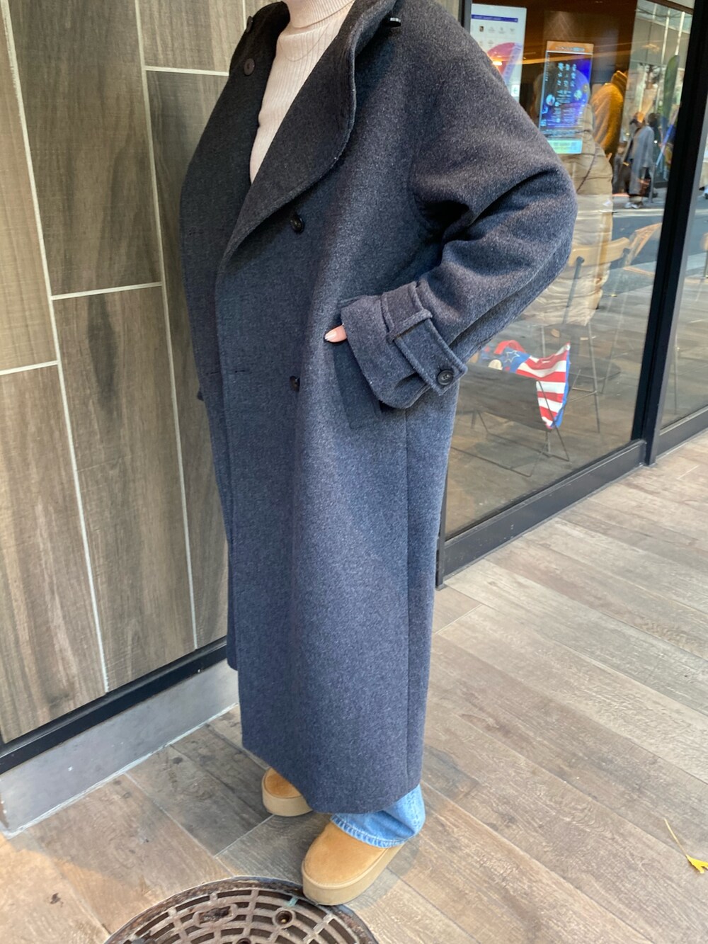 グレー系のその他アウター、ホワイト系のニット/セーター、ブルー系のデニムパンツを着用したレディースの冬コーディネートの6枚目の写真