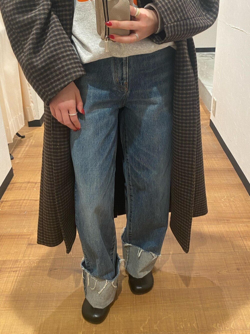 その他のチェスターコート、ブルー系のデニムパンツ、ブラック系のブーツを着用したレディースの秋コーディネートの4枚目の写真