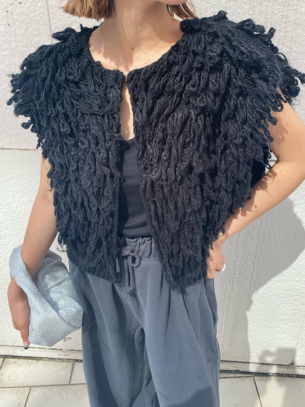 ブラック系のハンドバッグ、グレー系のスウェットパンツ、ブラック系のベストを着用したレディースの秋コーディネートの6枚目の写真