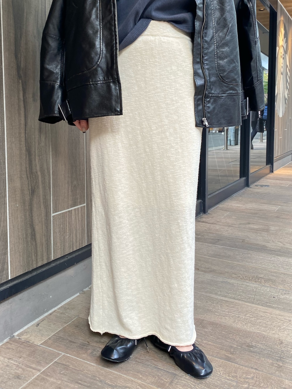 ホワイト系のスカート、ブラック系のブルゾン、グレー系のTシャツ/カットソーを着用したレディースの冬コーディネートの7枚目の写真