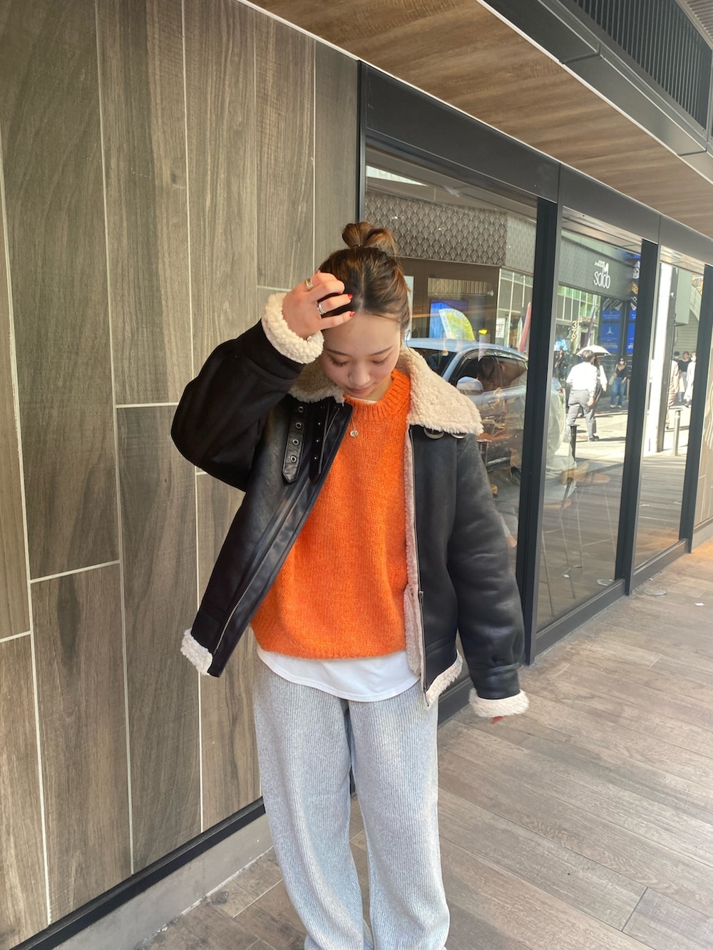 ブラック系のムートンコート、グレー系のその他パンツ、ブラック系のブーツを着用したレディースの秋コーディネートの3枚目の写真