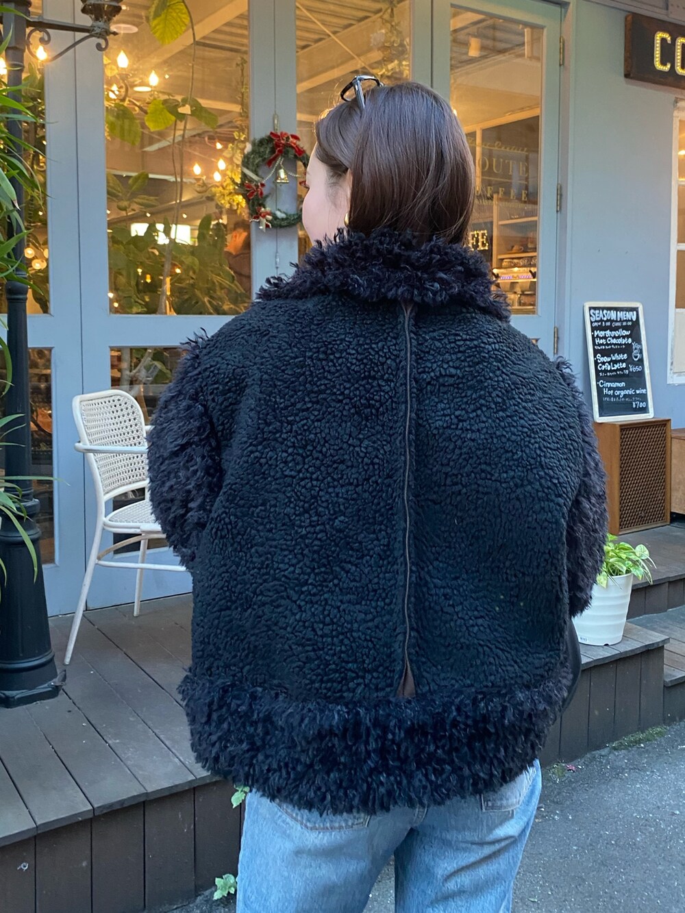 ブラック系のムートンコートを着用したレディースの冬コーディネートの5枚目の写真