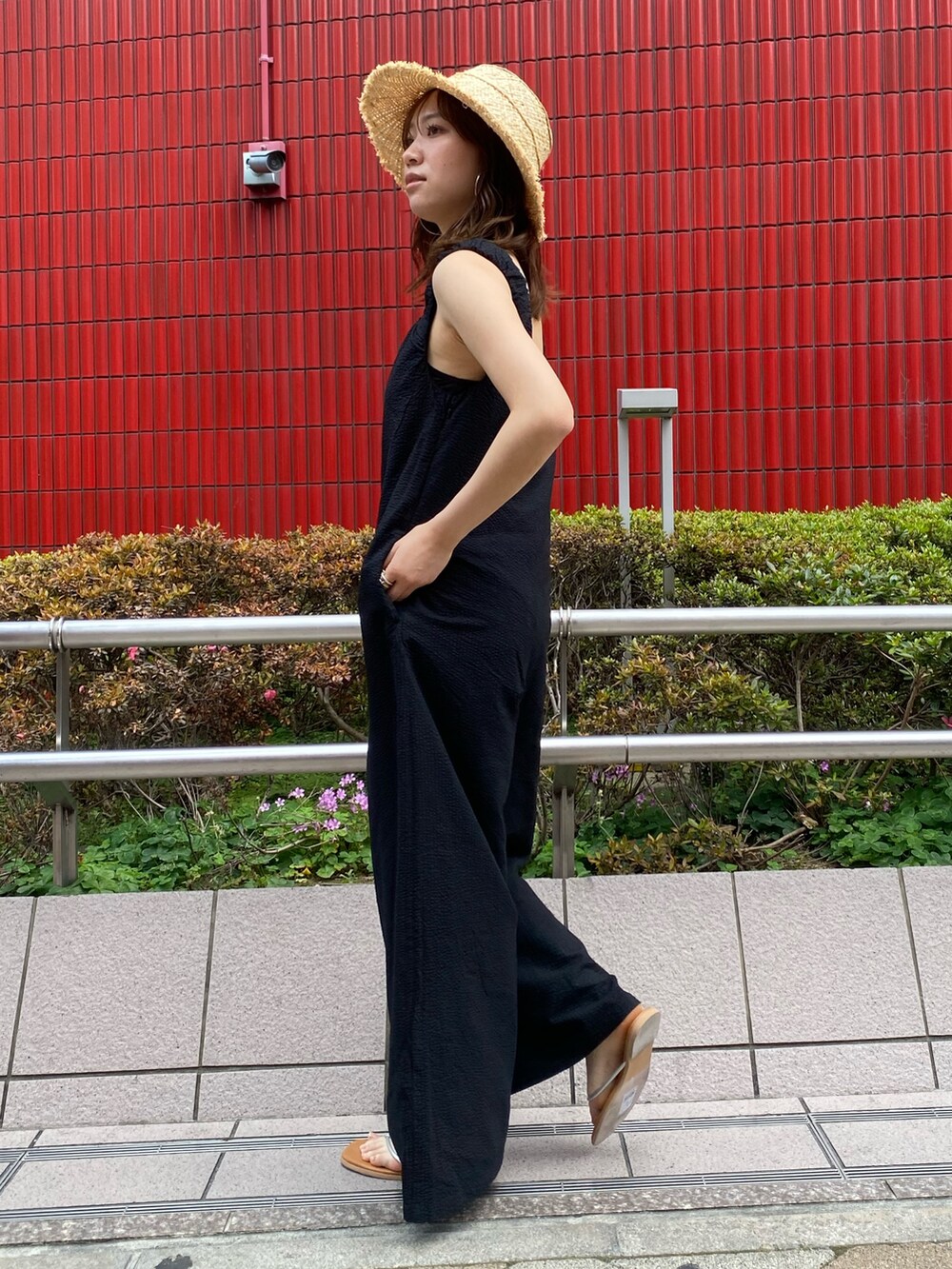 シルバー系のサンダル、ブラック系のつなぎ/オールインワン、ベージュ系のハットを着用したレディースの夏コーディネートの2枚目の写真