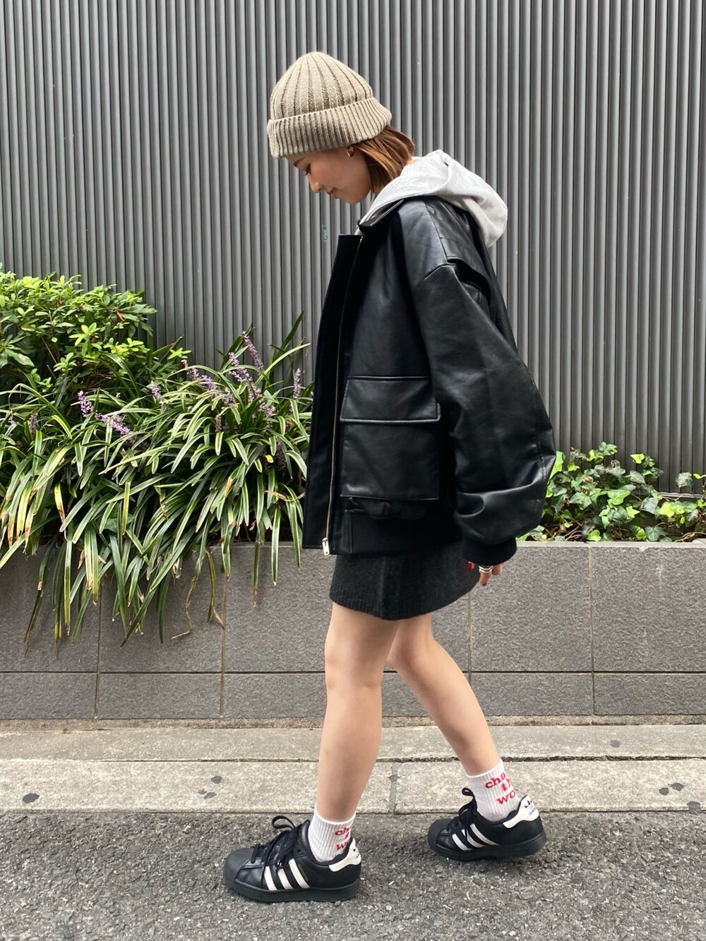 グレー系のスカート、ブラック系のブルゾン、グレー系のパーカーを着用したレディースの秋コーディネートの4枚目の写真