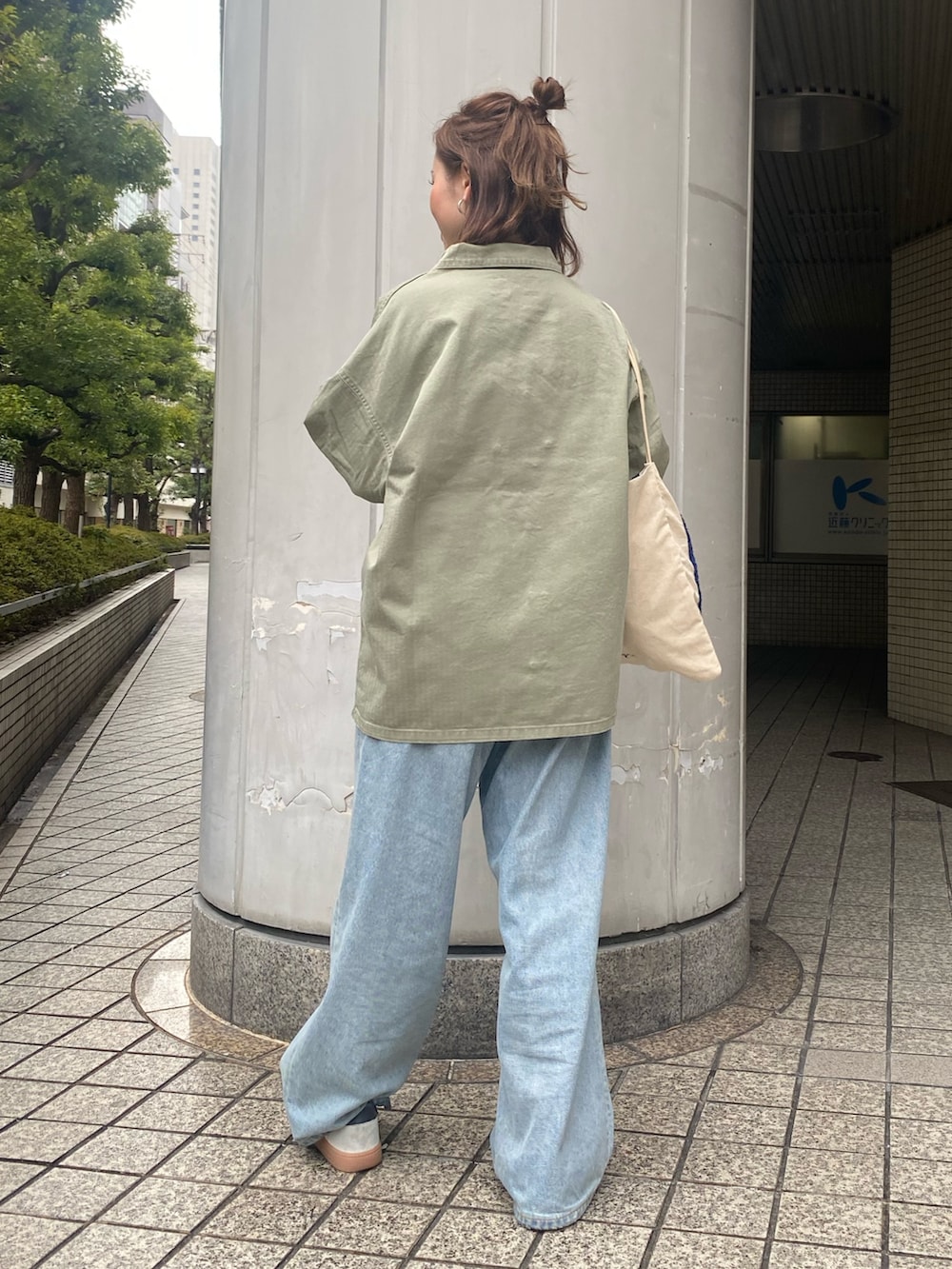 ブルー系のデニムパンツ、グリーン系のミリタリージャケット、ホワイト系のTシャツ/カットソーを着用したレディースの春コーディネートの3枚目の写真