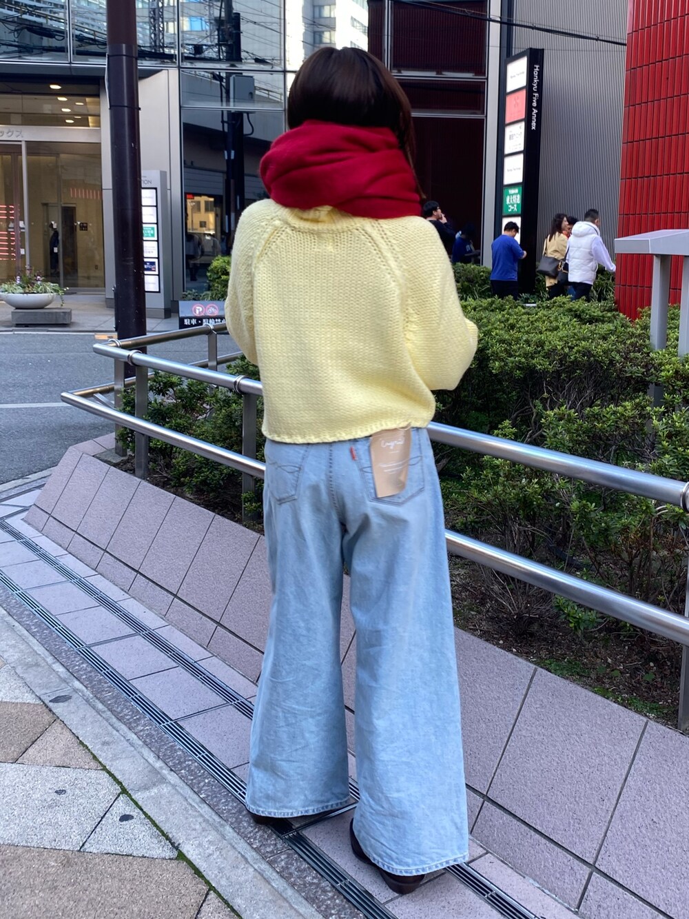 ブルー系のデニムパンツ、イエロー系のニット/セーター、ブラウン系のブーツを着用したレディースの秋コーディネートの3枚目の写真